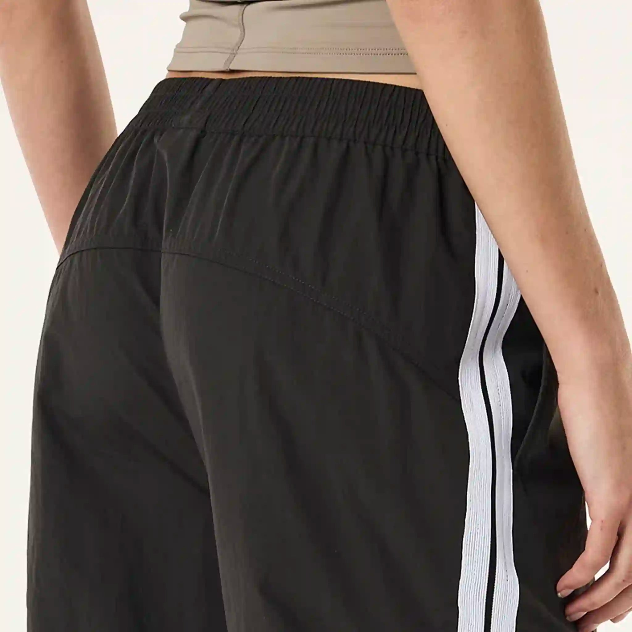 Black pants with a white stripe on a neutral background