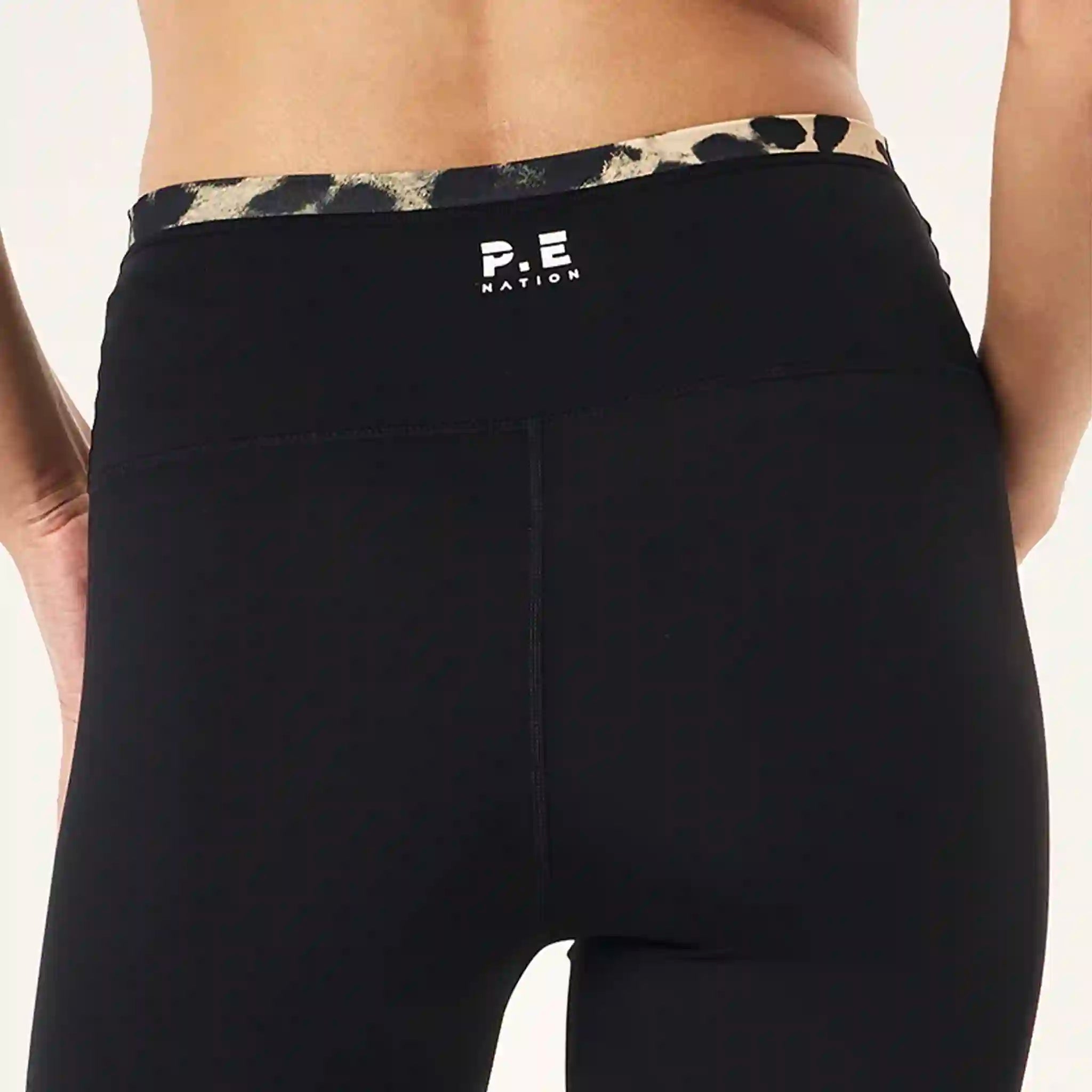 Black leggings with a leopard print waistband and 'P.E Nation' logo on a white background