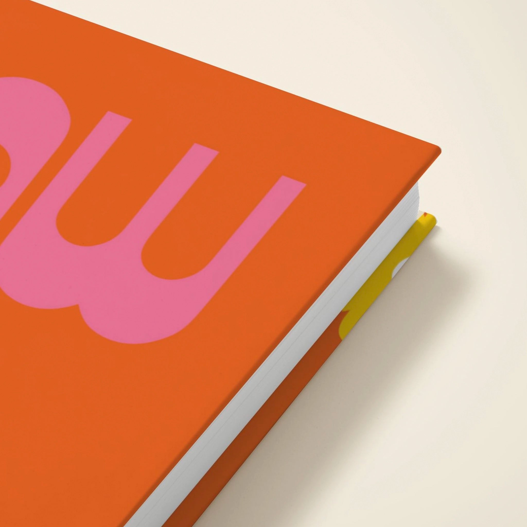Orange notebook with pink letter 'W' on a beige background