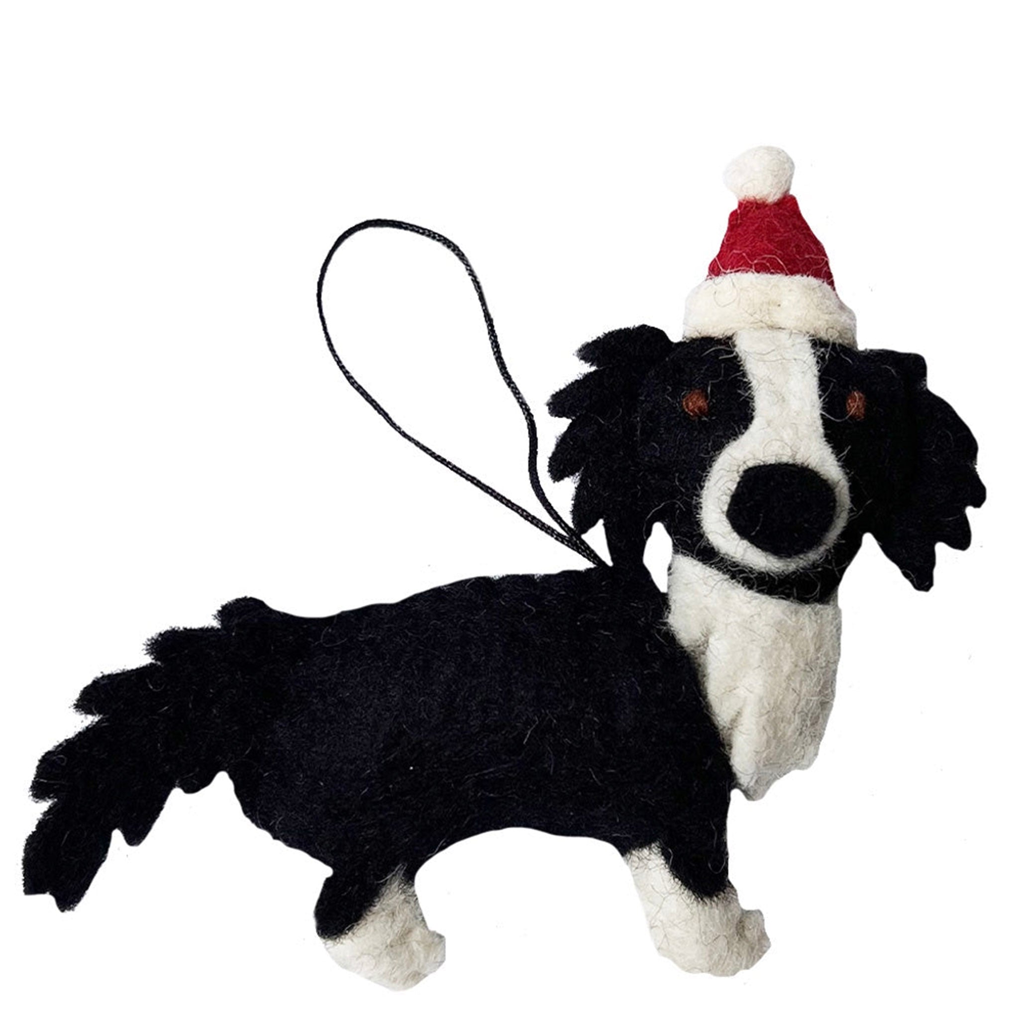 Black and white dog-shaped ornament with a Santa hat on a white background
