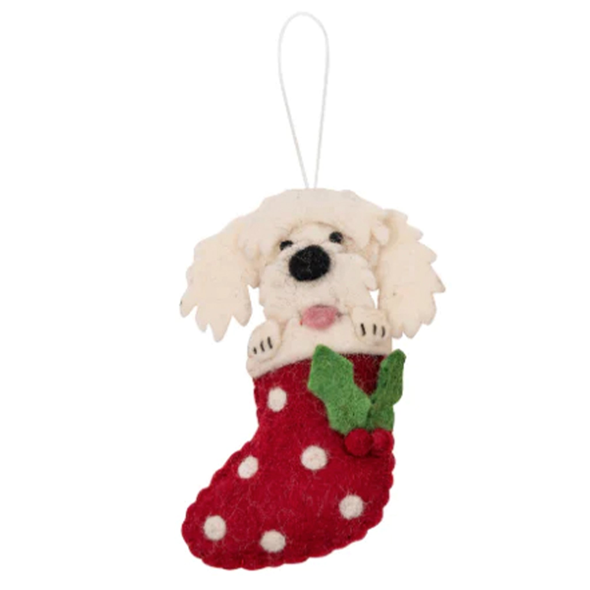 White felt dog ornament in a red stocking with holly leaves on a white background