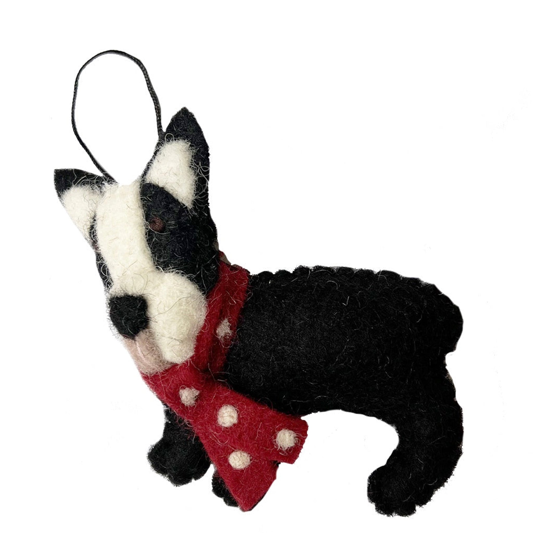 Black and white dog-shaped ornament with a red scarf on a white background