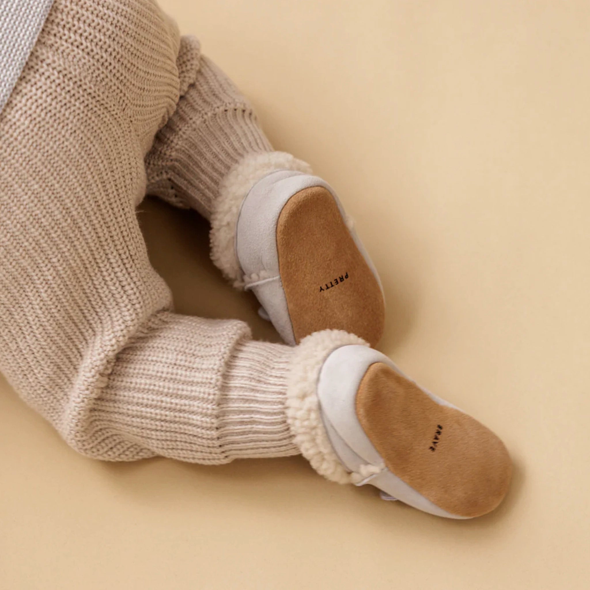 Close-up of beige knit socks with white soles on a beige background
