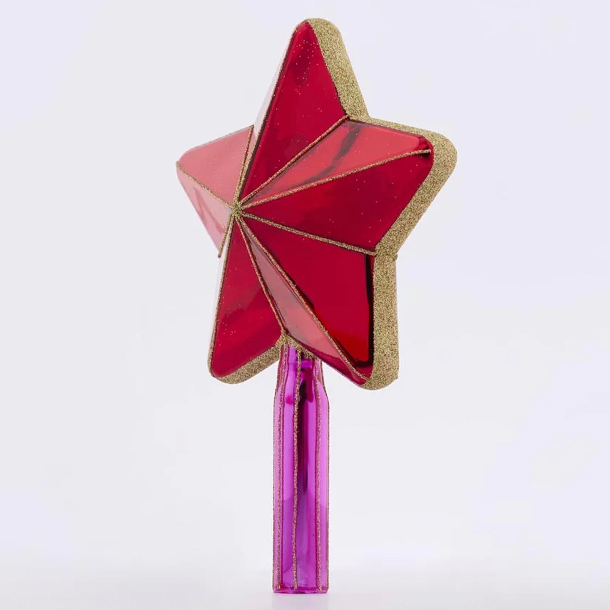 red star-shaped tree topper on a grey background