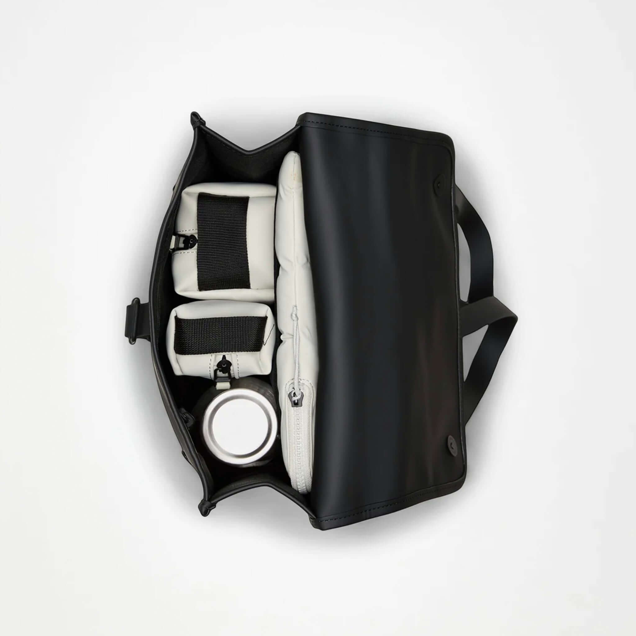 Interior view of the Rains Backpack Mini - Black, showcasing compartments for laptop and essentials.