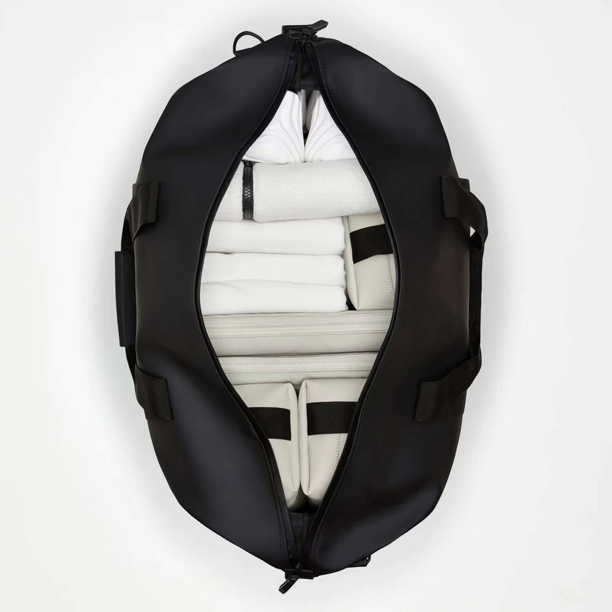Interior view of the Rains Hilo Weekend Bag - Green showing neatly organized towels and compartments.