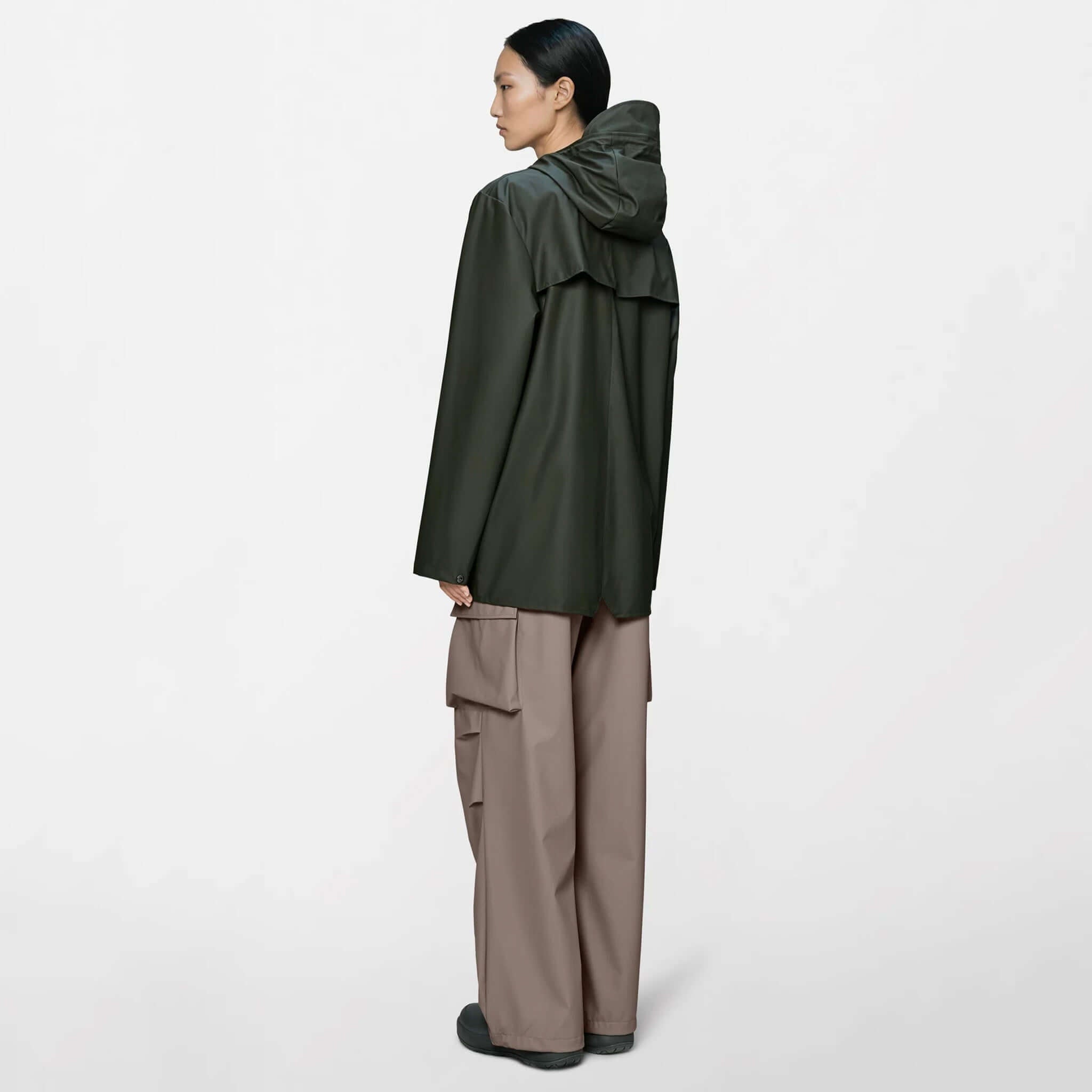Rains Jacket - Green worn by a model with the back view featuring a drawstring hood and pockets.