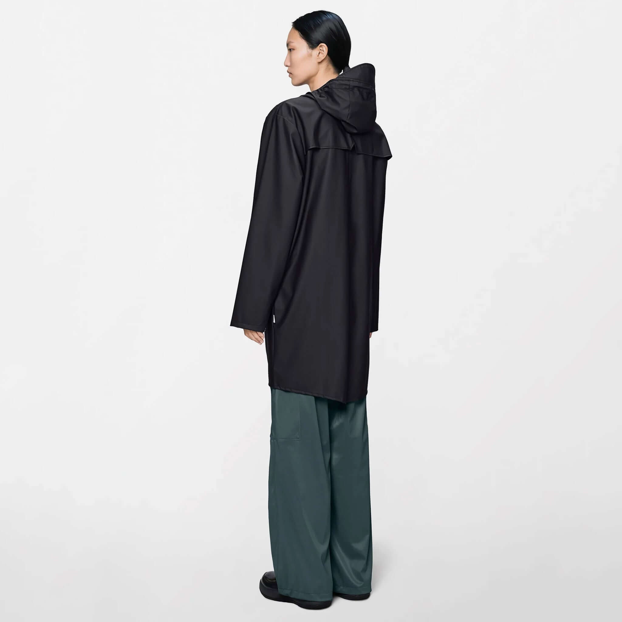 Rains Long Jacket - Black, featuring a minimal design and adjustable hood, offering extra coverage.