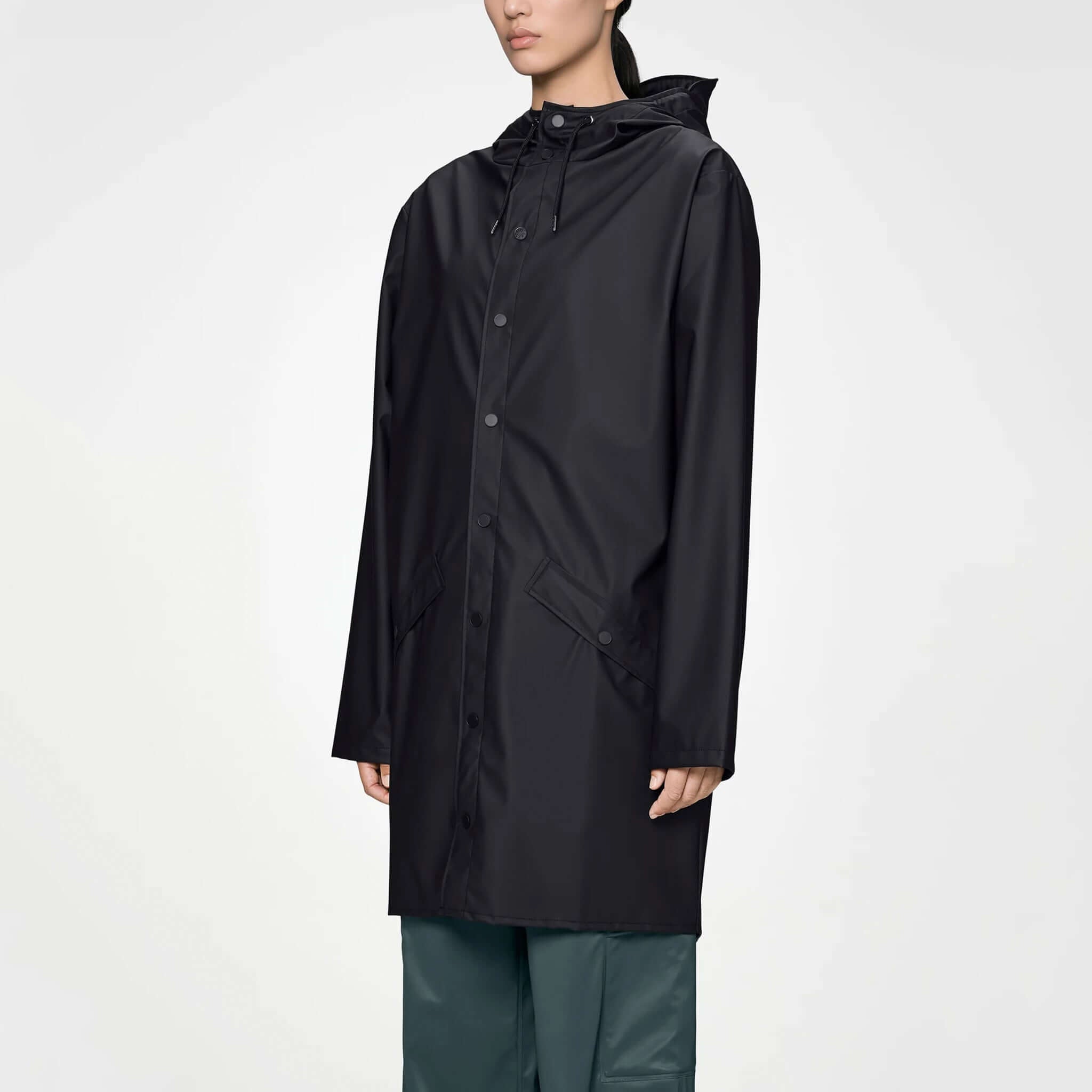 Rains Long Jacket - Black displayed on a model, showcasing its sleek, waterproof design and adjustable hood.