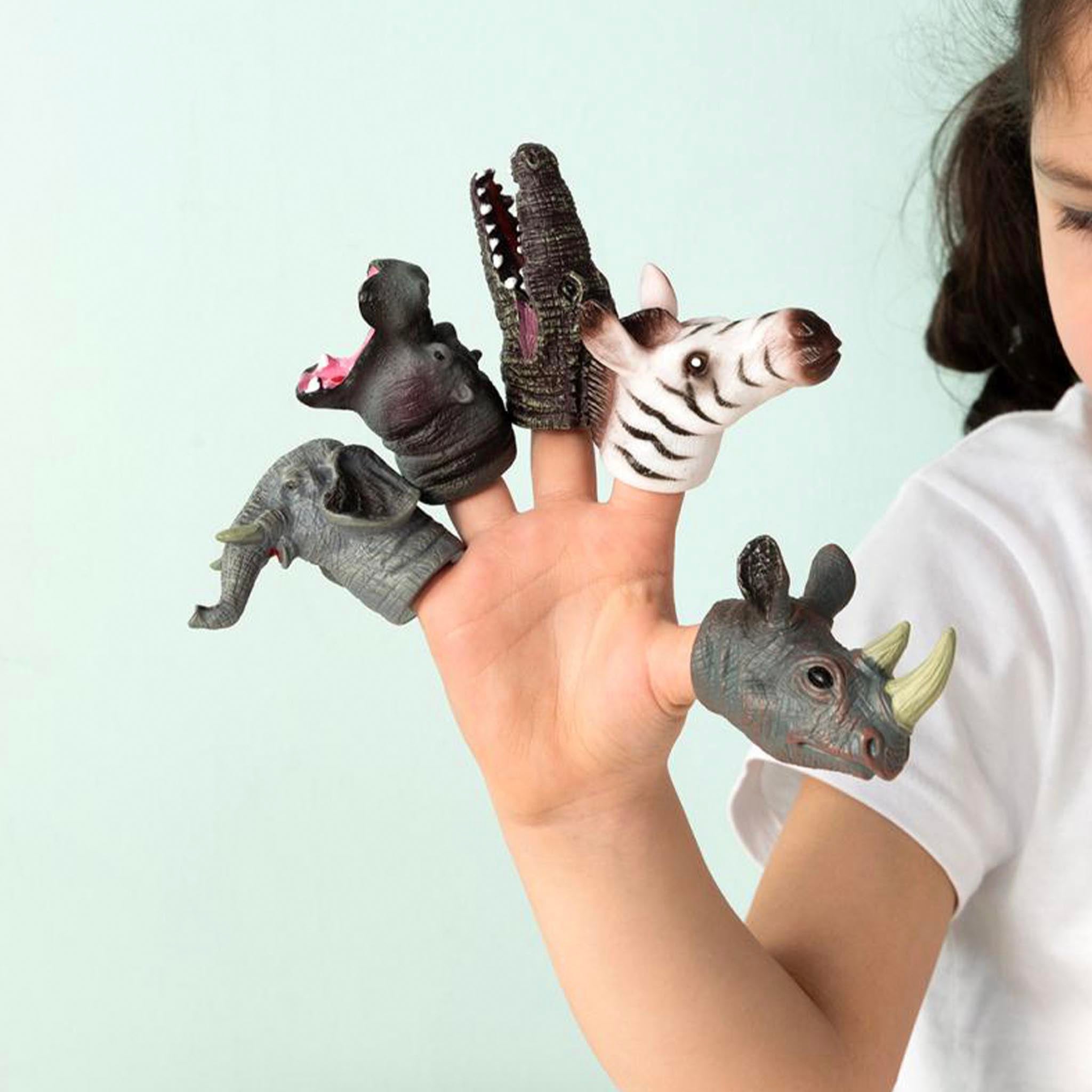 Finger puppets of a zebra, rhino, elephant, and hippo on a person's hand against a light blue background.
