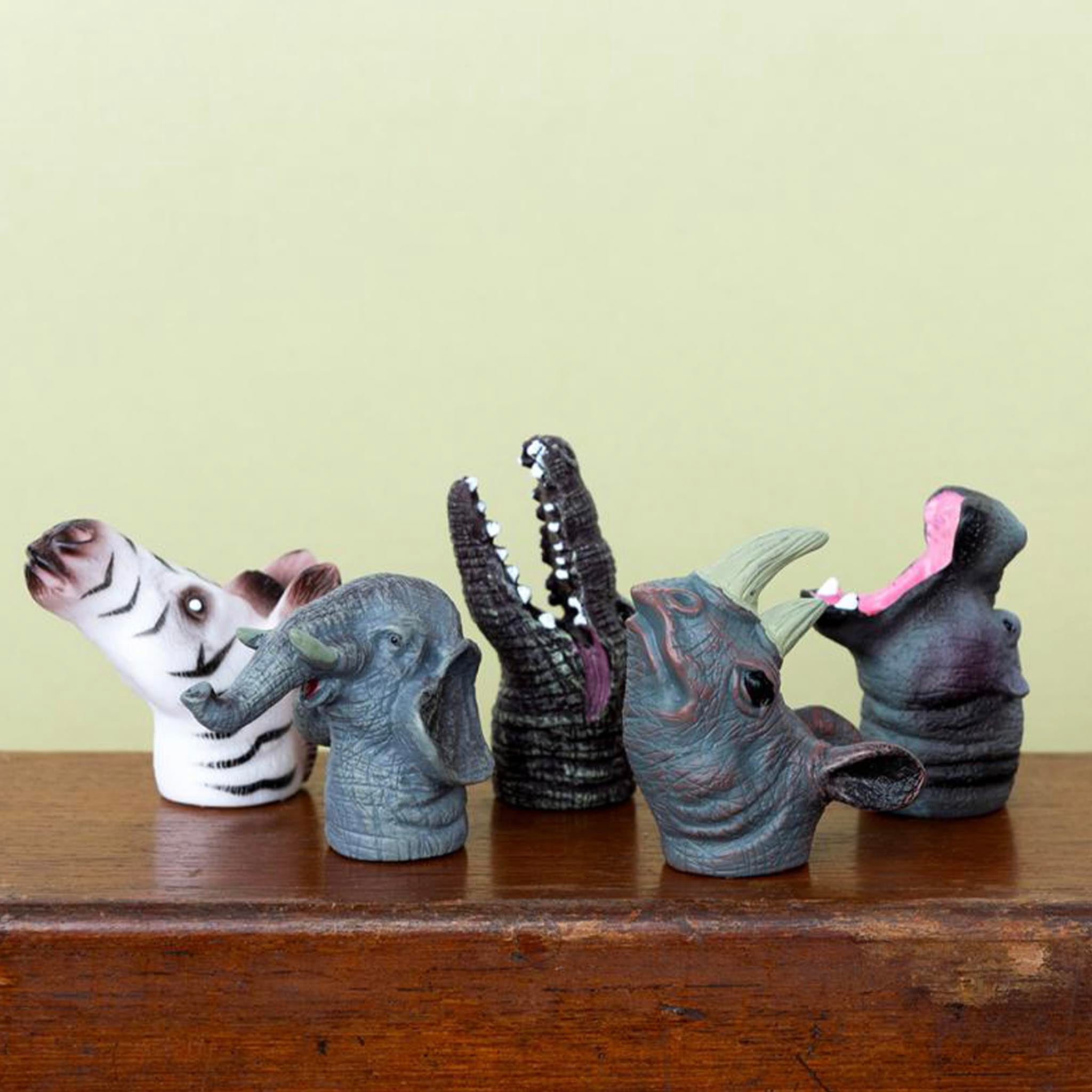 Five animal head-shaped vases on a wooden surface with a plain background