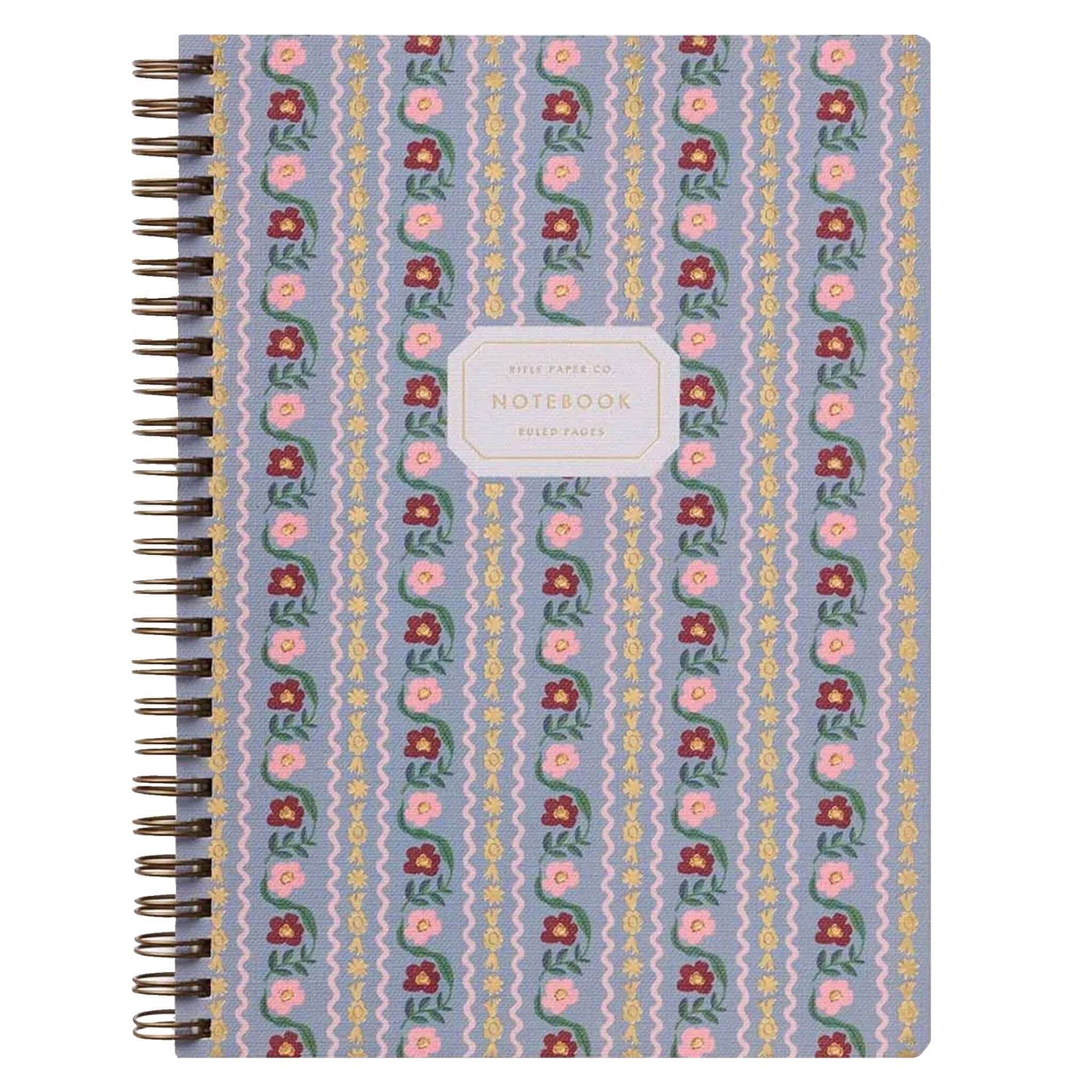 Rifle Paper Spiral Notebook - Delphine with floral stripes in pink, burgundy, and green on periwinkle blue.