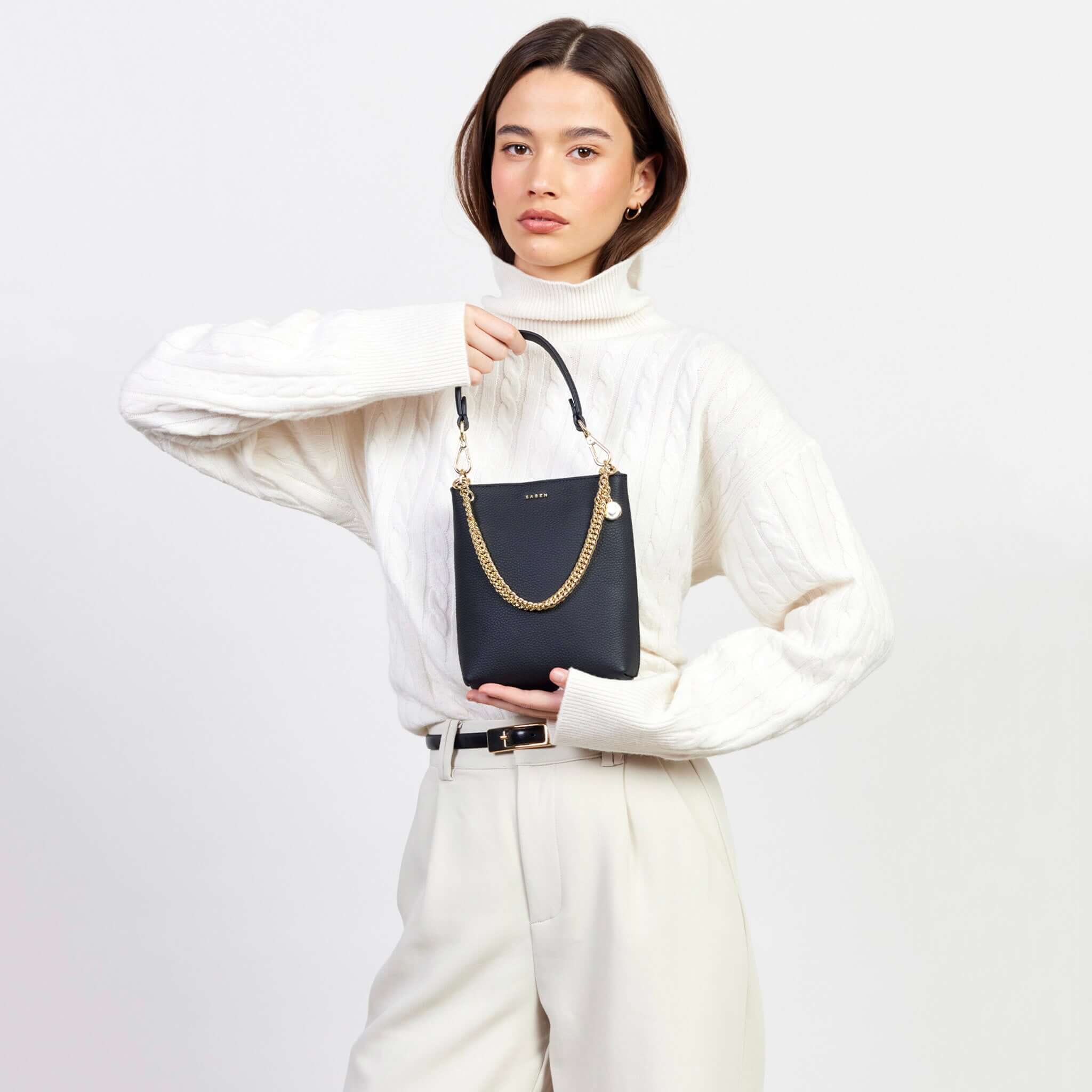 Alt Tag: Saben Coco Mini Bag - Black on model with detachable leather strap and gold chain handle, compact mini bag for essentials