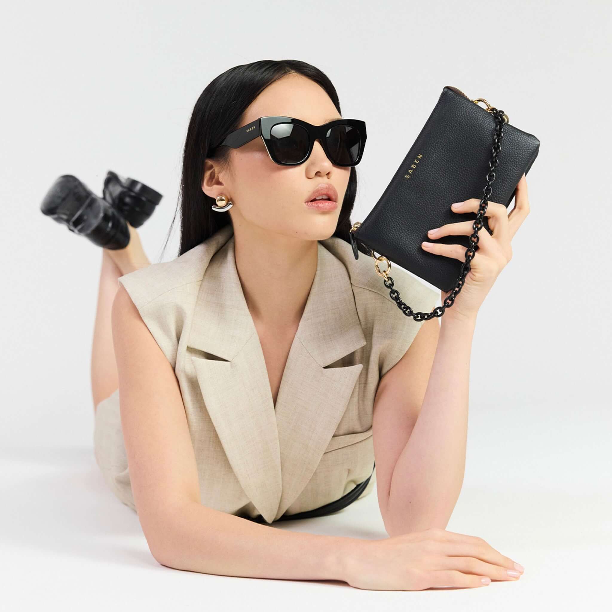 Model showcasing Saben Feature Chain Handle - Black Link with a stylish black clutch and sunglasses.
