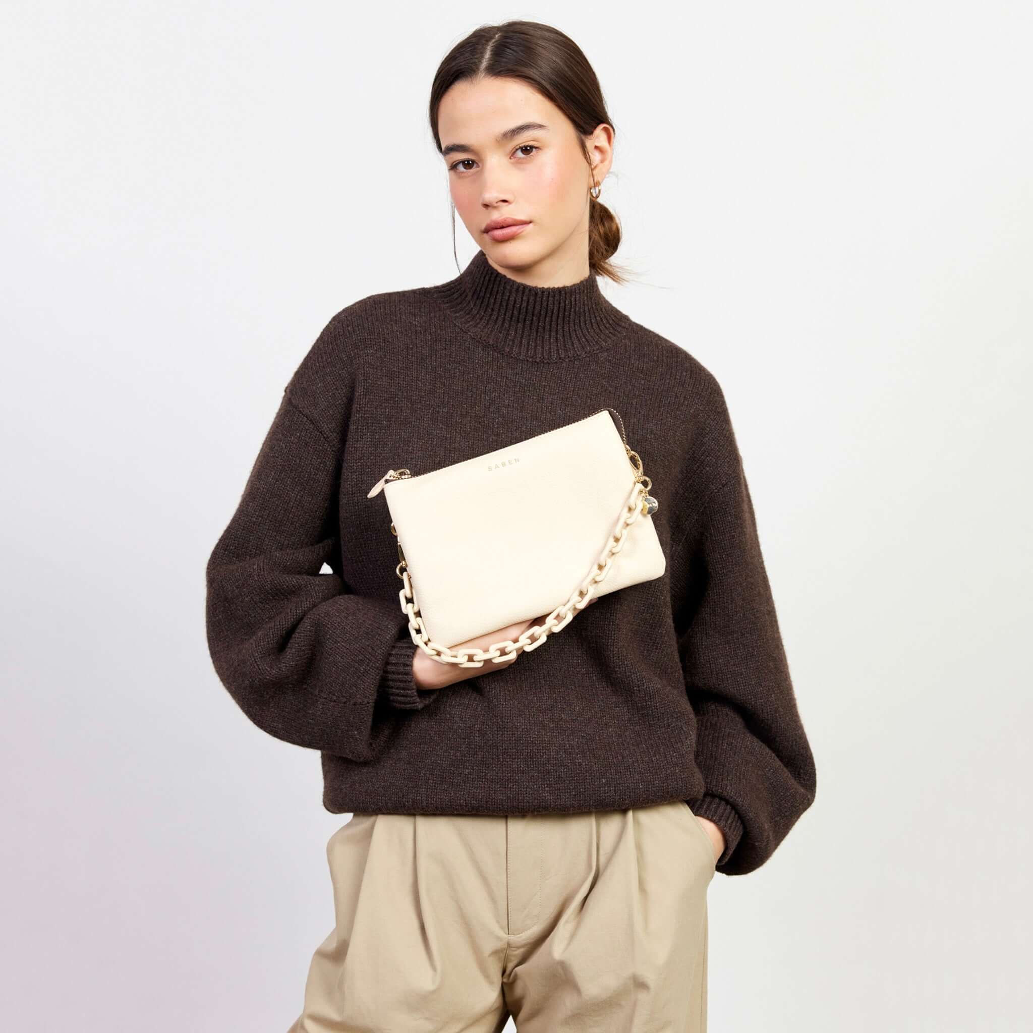 Saben Feature Chain Handle - Vanilla Chunky on cream clutch bag, worn as chunky chain strap for a glitzy wristlet look