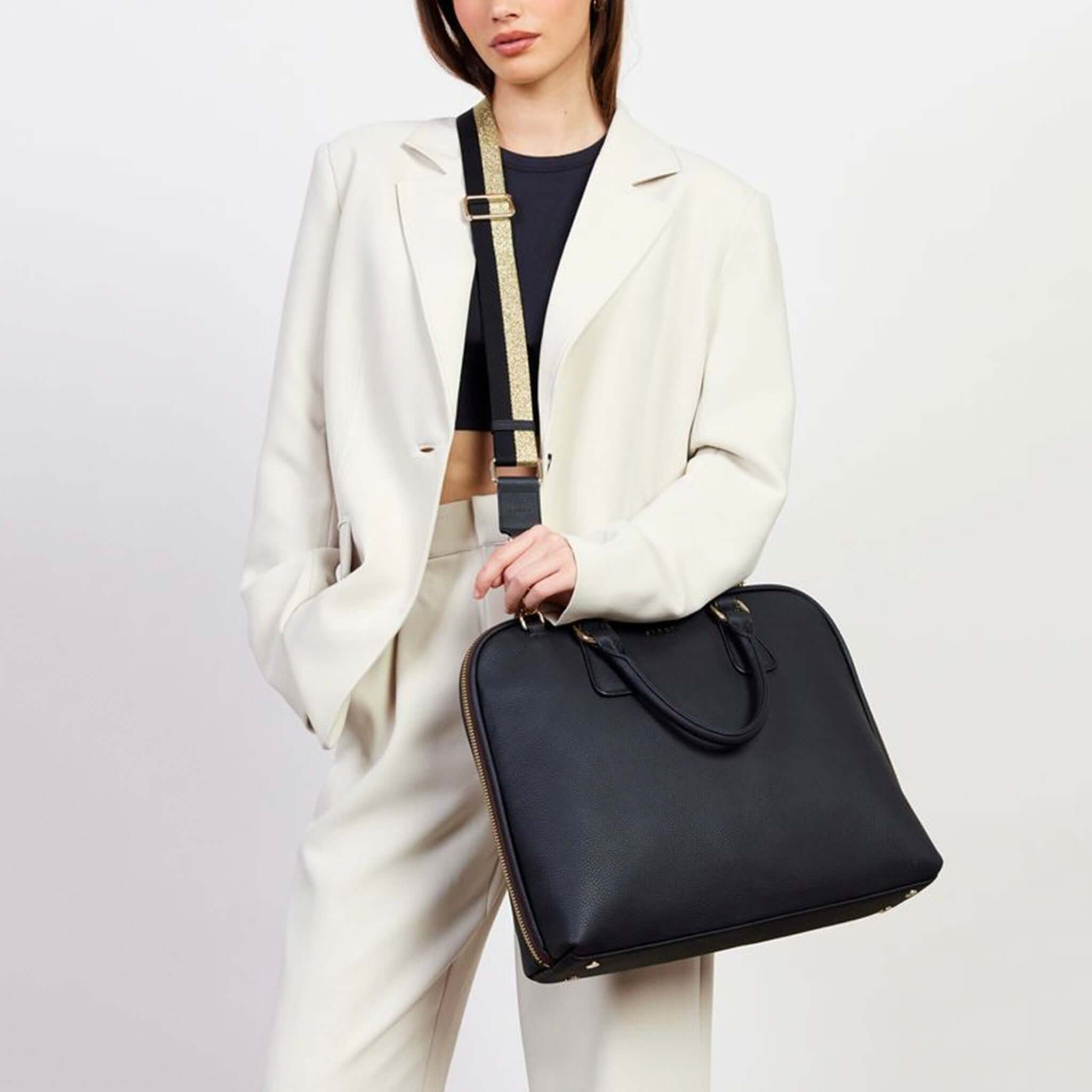 Alt Tag: Saben Feature Webbing Strap - Gold & Black Stripe crossbody cotton webbing strap with leather trim and gold hardware on black bag