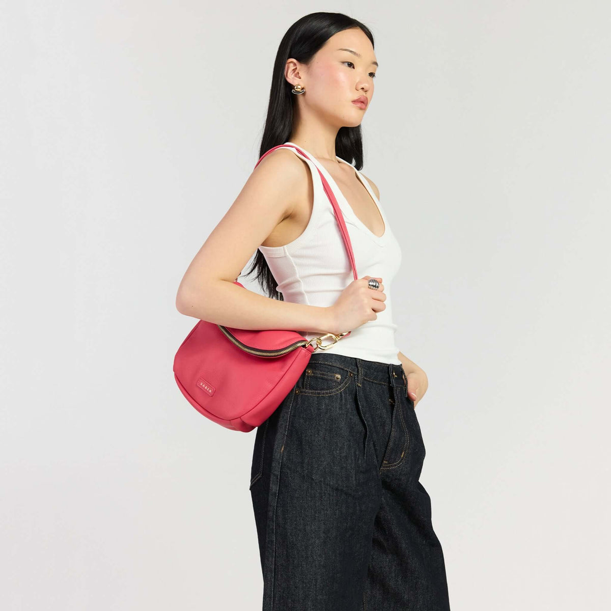 Saben Fifi Crossbody Bag - Azalea worn by a model in casual attire against a neutral background