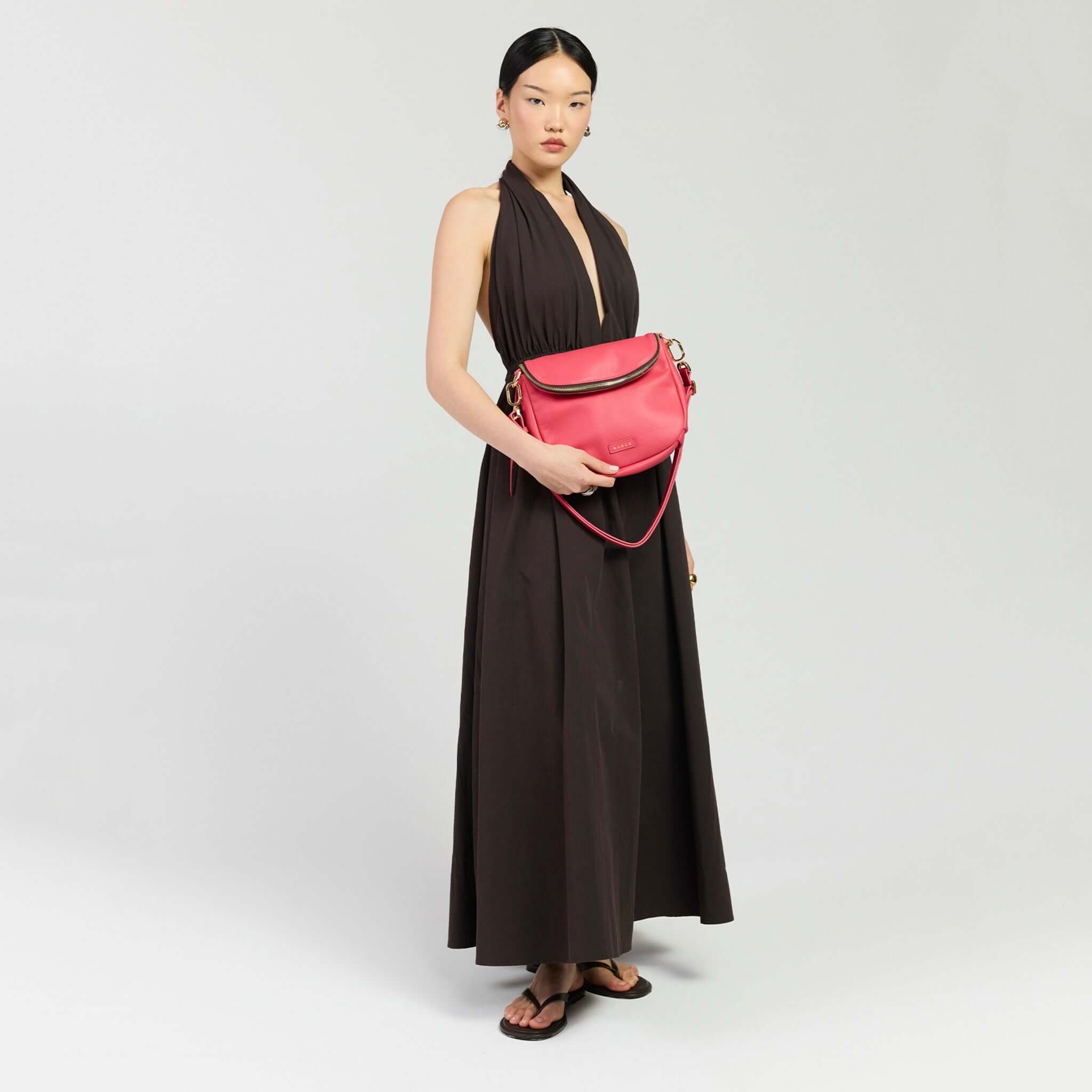 Model showcasing the Saben Fifi Crossbody Bag - Azalea with a chic outfit and accessories.