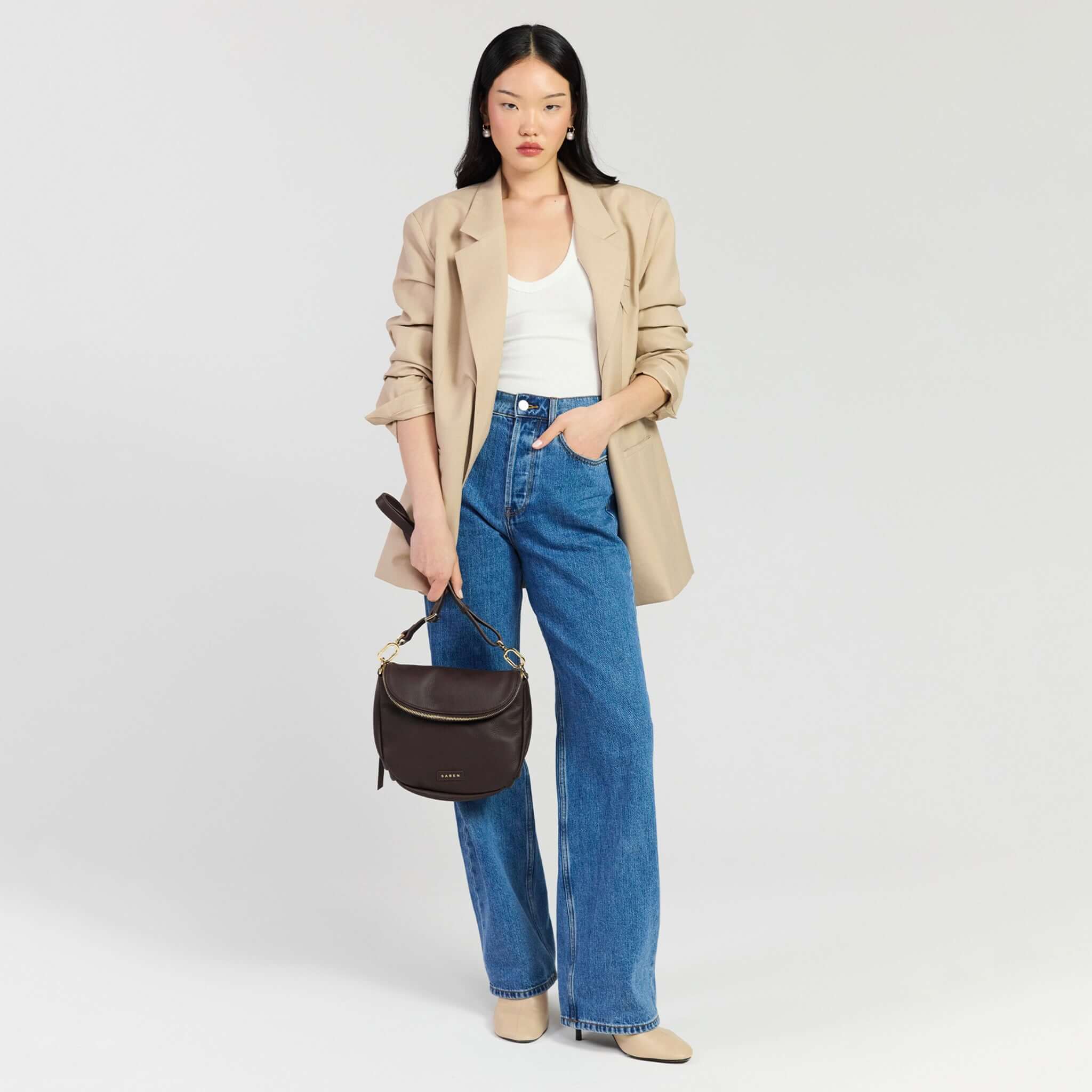 Saben Fifi Crossbody Bag - Cacao styled with a chic outfit featuring a beige blazer and high-waisted jeans.