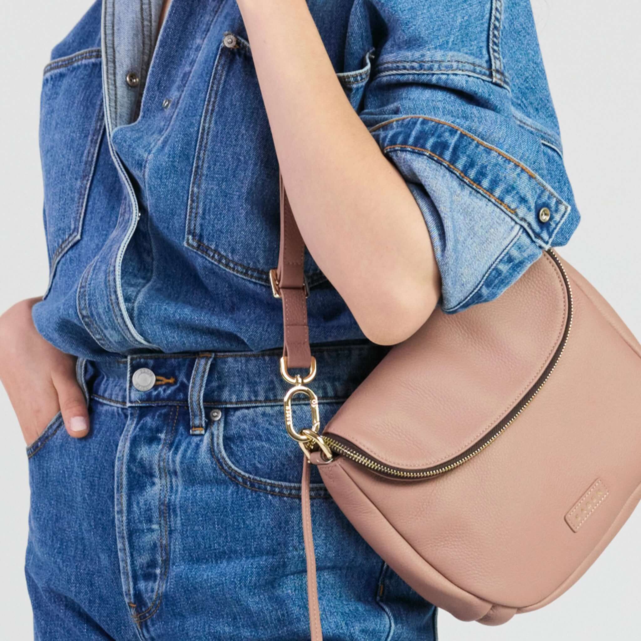 Saben Fifi Crossbody Bag - Rosewater worn casually with a denim outfit, showcasing its chic design and style.