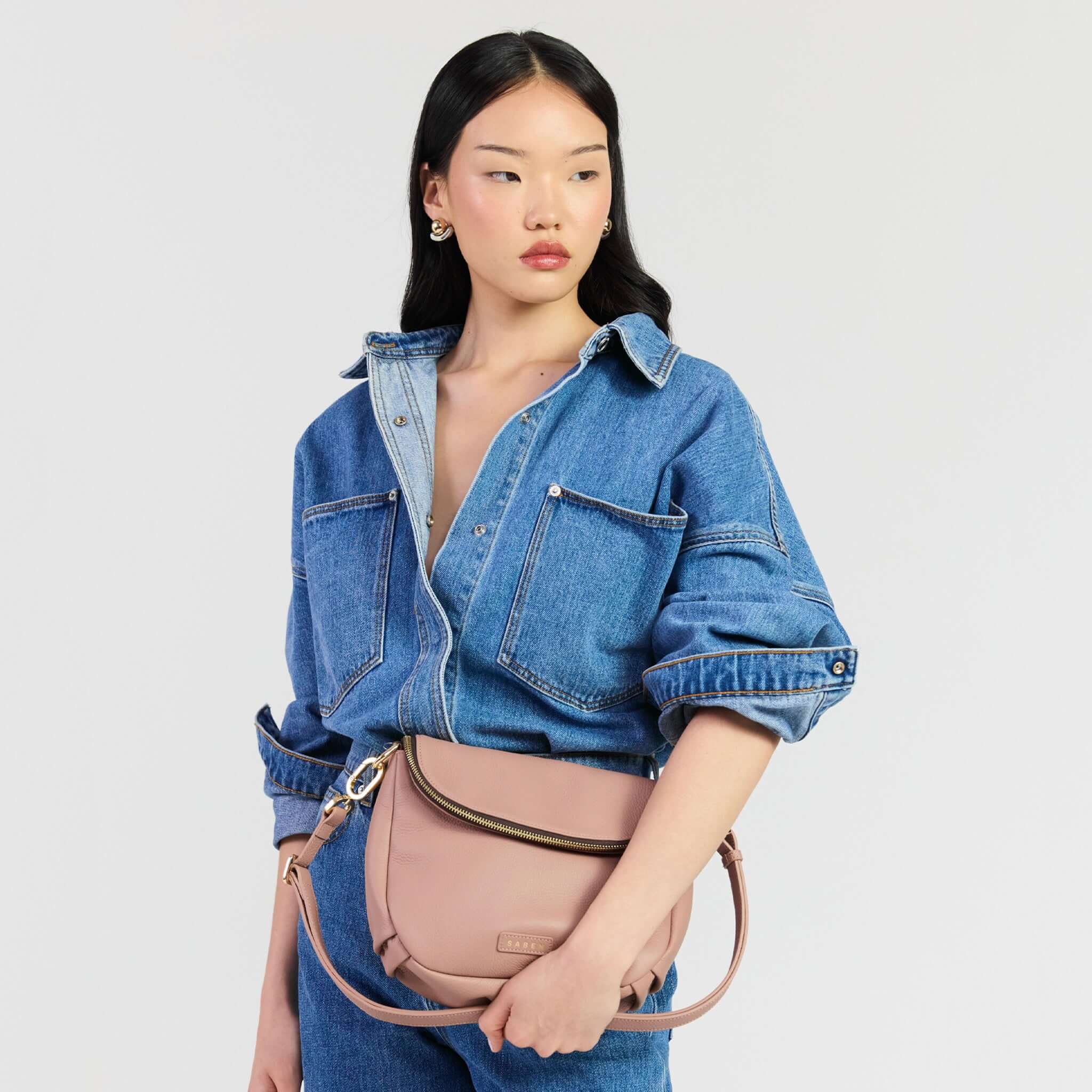 Saben Fifi Crossbody Bag - Rosewater worn with a chic denim shirt, showcasing its stylish design and compact elegance.