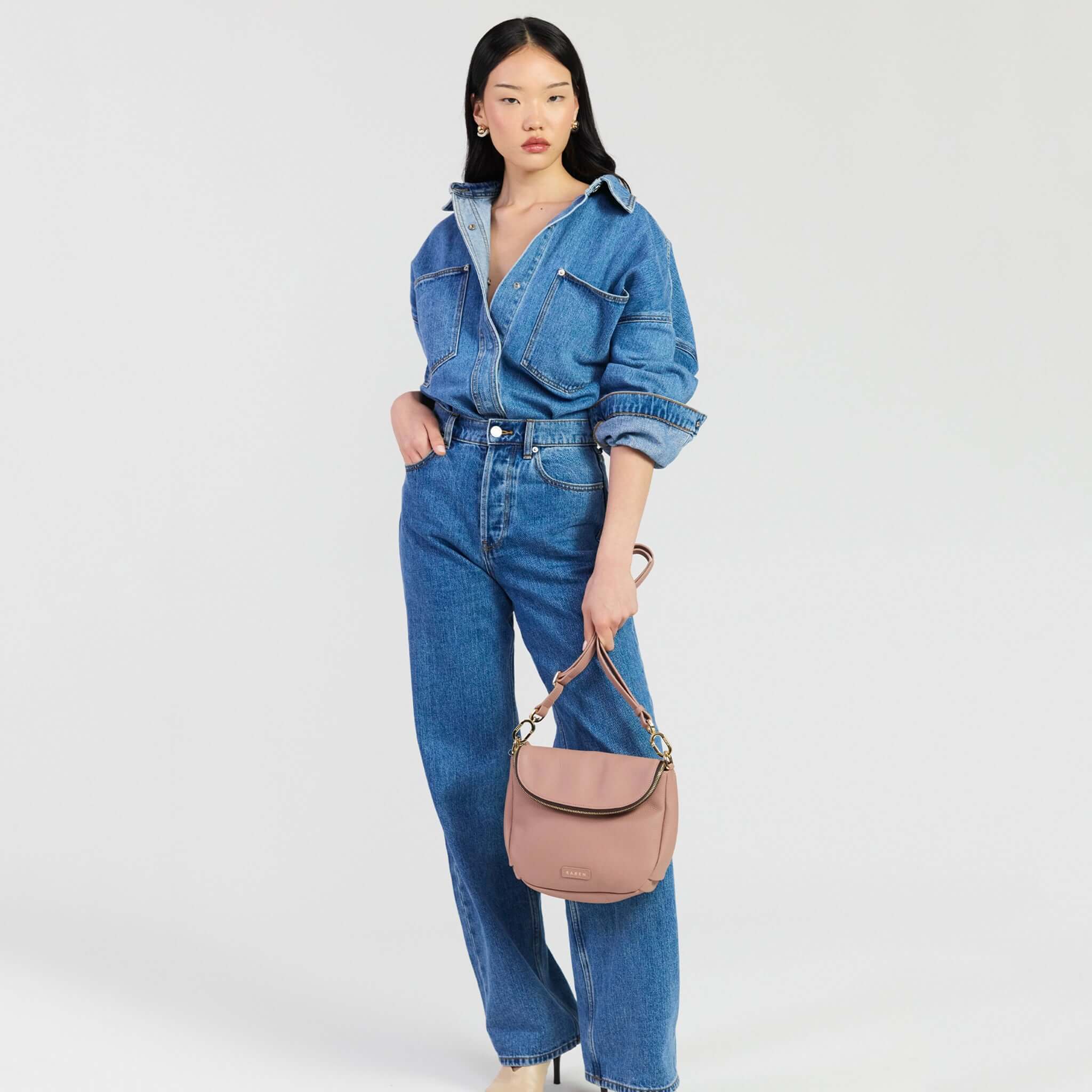 Saben Fifi Crossbody Bag - Rosewater displayed with casual denim outfit, showcasing its chic design and compact style.