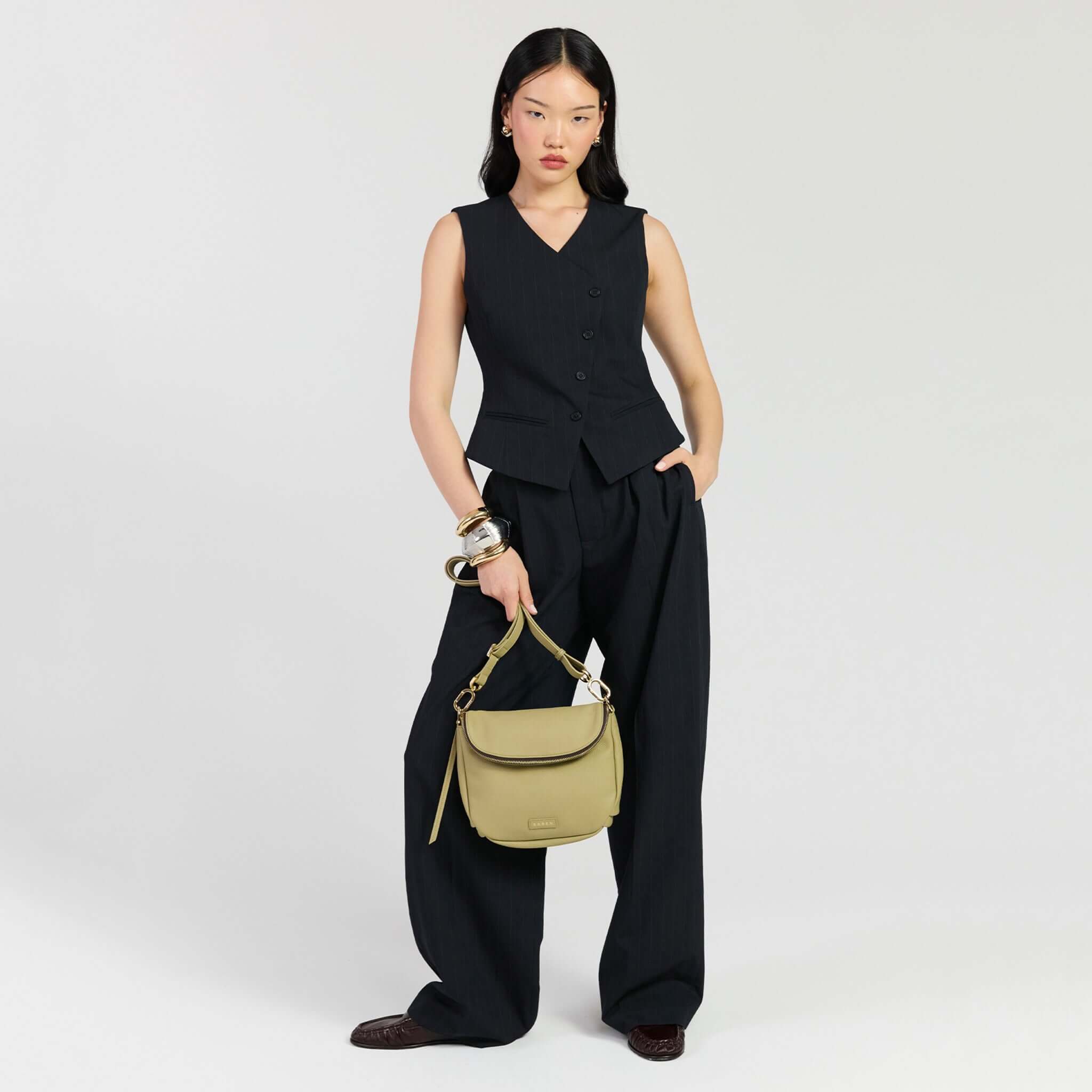 Model showcasing Saben Fifi Crossbody Bag - Willow with stylish outfit, highlighting its chic design and functionality.