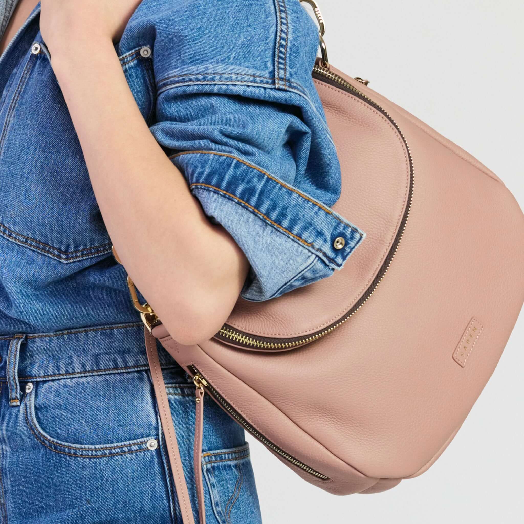 Saben Frankie Shoulder Bag - Rosewater being carried in a casual outfit featuring denim.