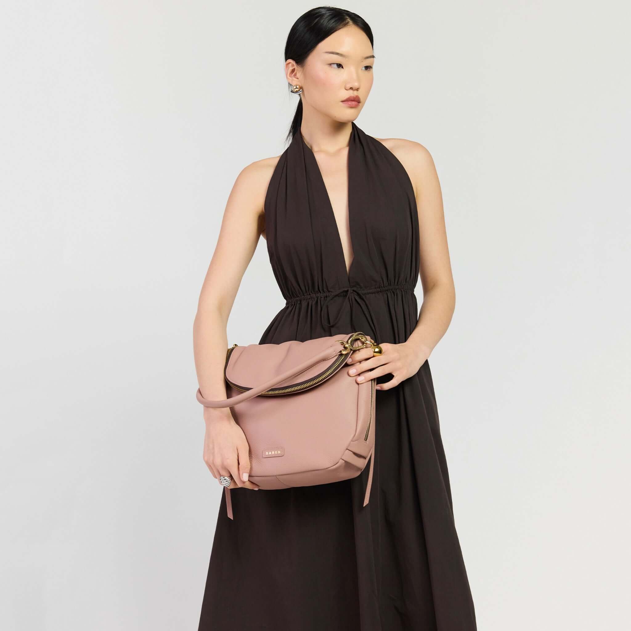 Saben Frankie Shoulder Bag - Rosewater being showcased by a model in a stylish halter dress.