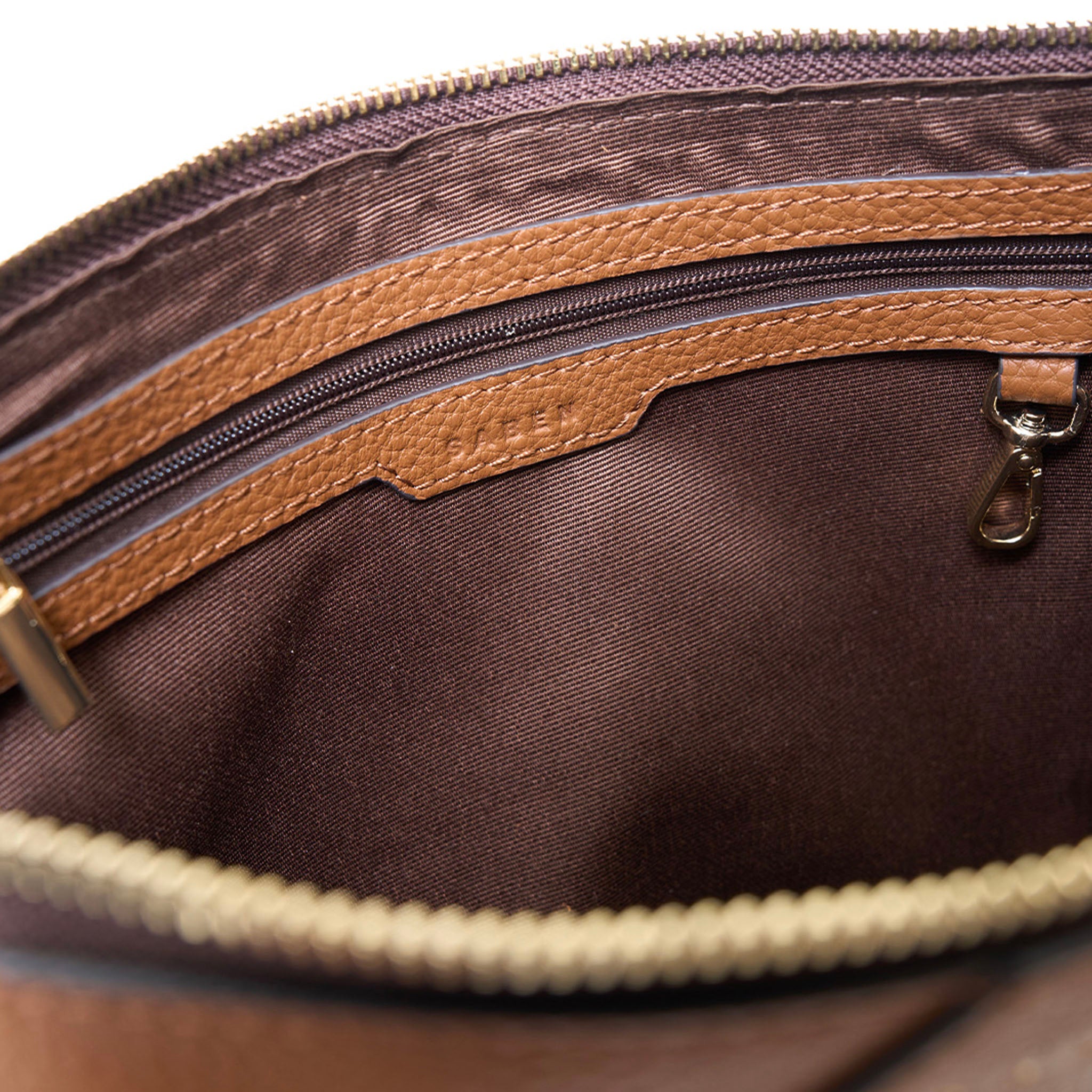 Close-up of a brown leather bag with gold zipper and hardware.