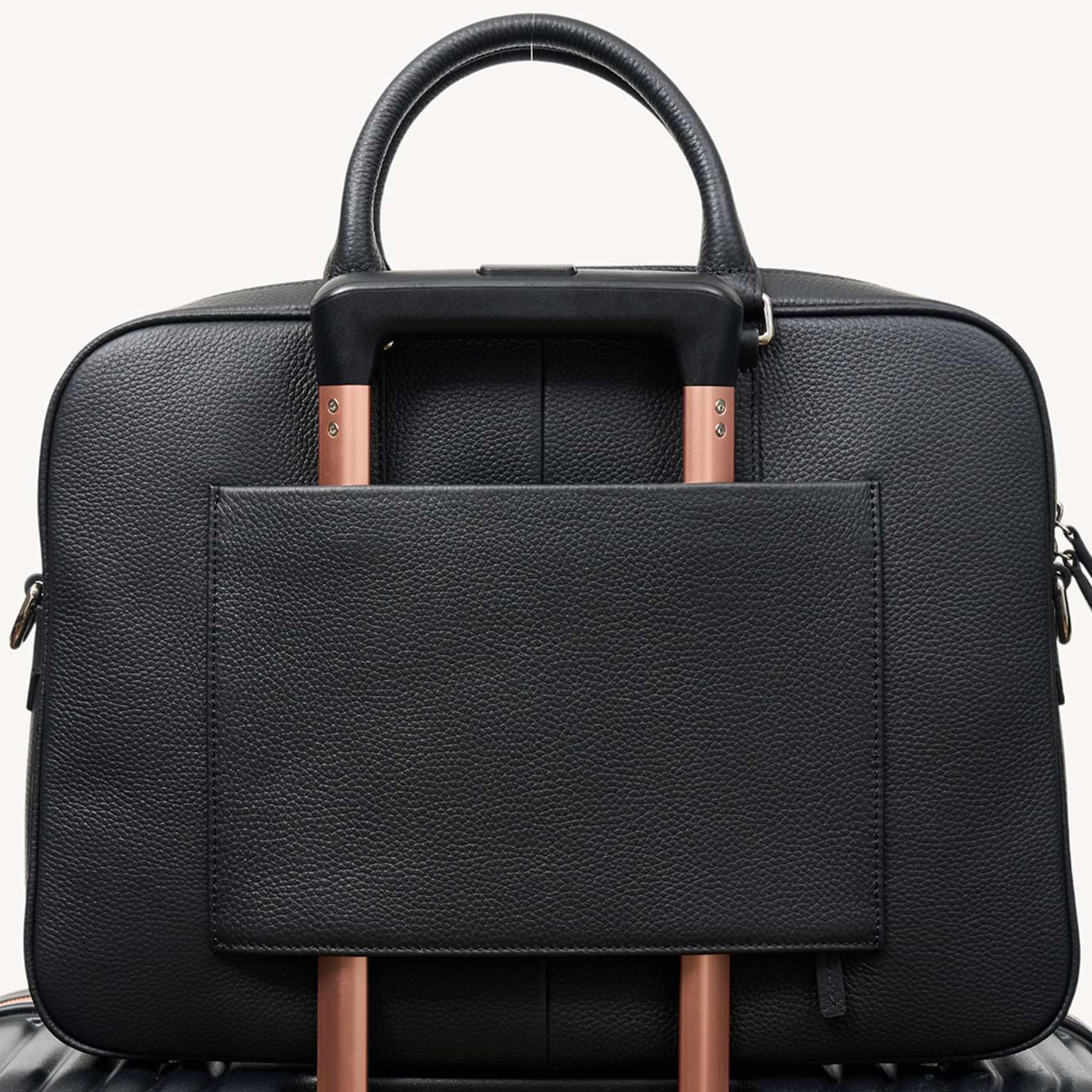 Black Saben briefcase on a suitcase on a white background.