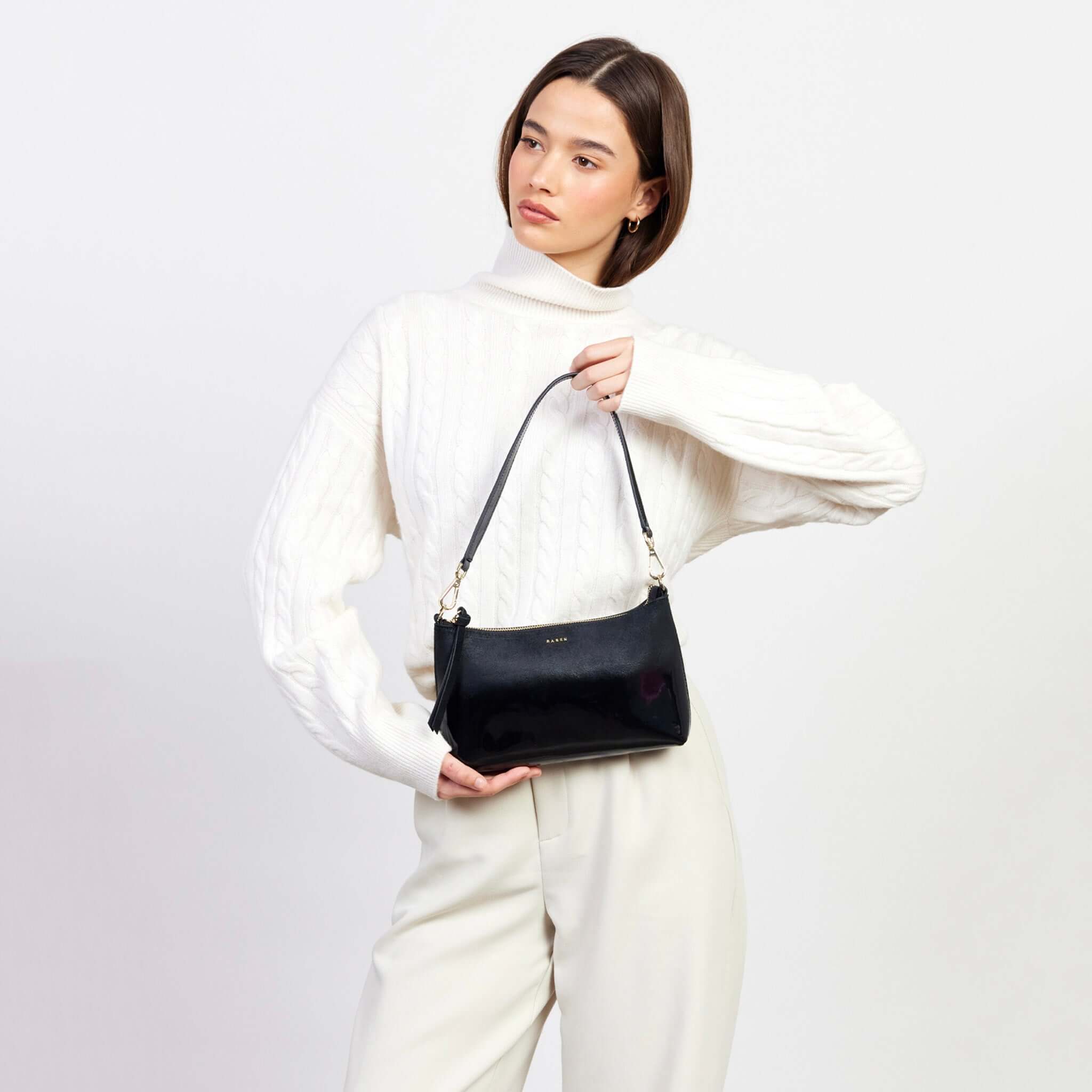 Alt Tag: Model holding Saben Haven Shoulder Bag - Black Dipped, compact black shoulder bag with strap for nights out and weekend brunch