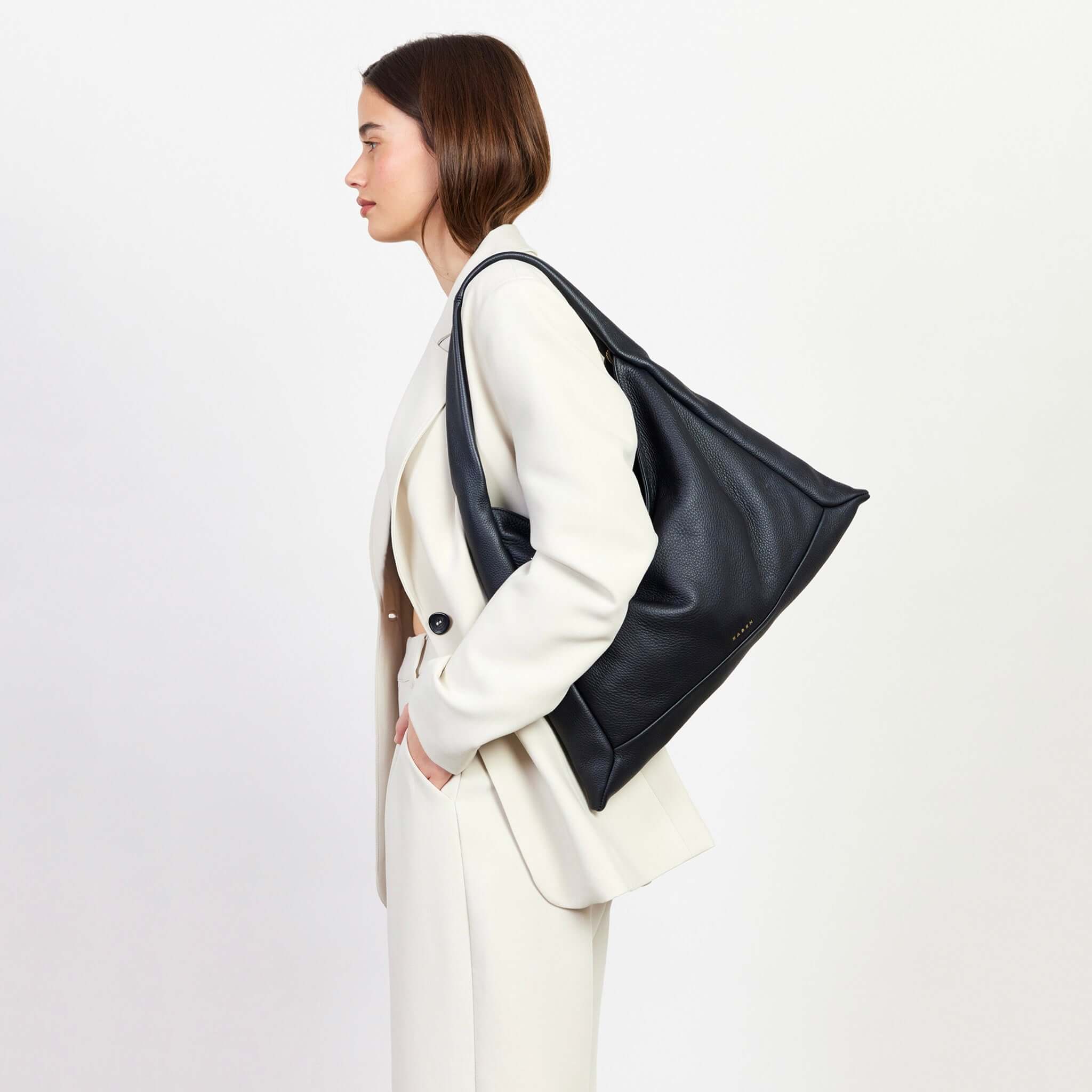 Alt Tag: Saben Haze Shoulder Bag - Black Luxe black soft cowhide slouch shoulder tote on model, minimalist sculptural everyday bag