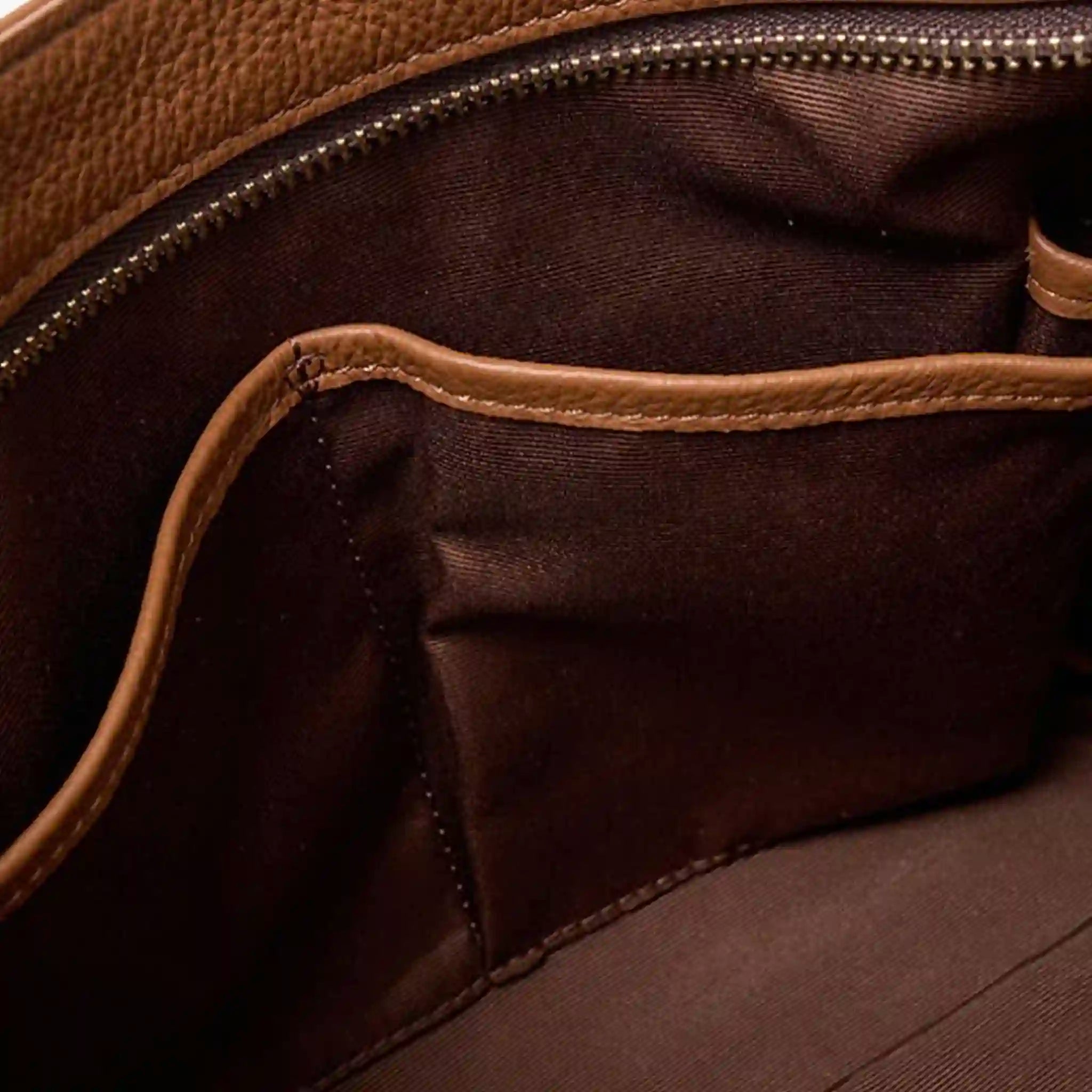 Close-up of a brown leather bag with visible stitching and texture.