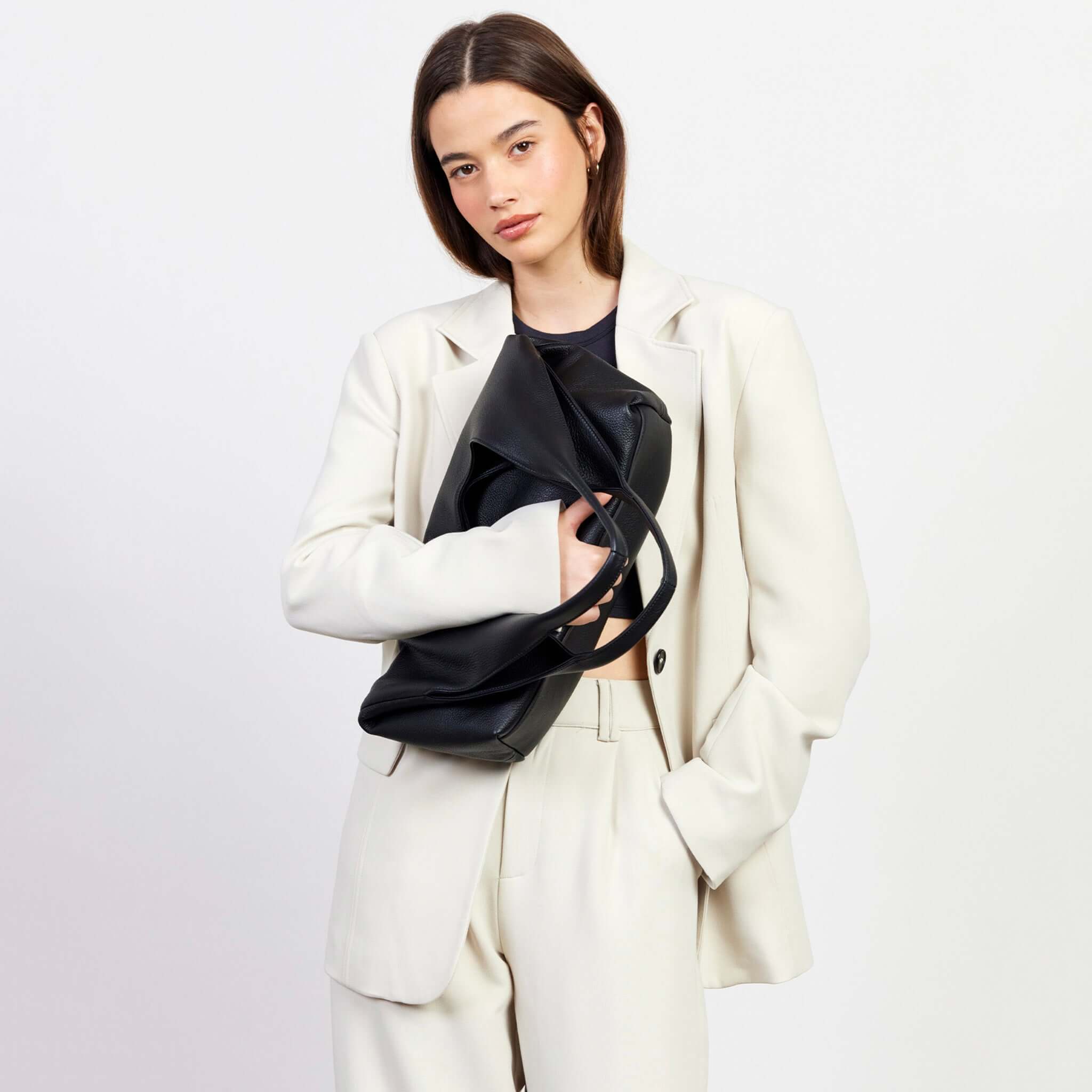 Alt Tag: Model holding Saben Kip Shoulder Bag - Lightly Milled Black slouchy black leather shoulder bag, roomy everyday essentials style