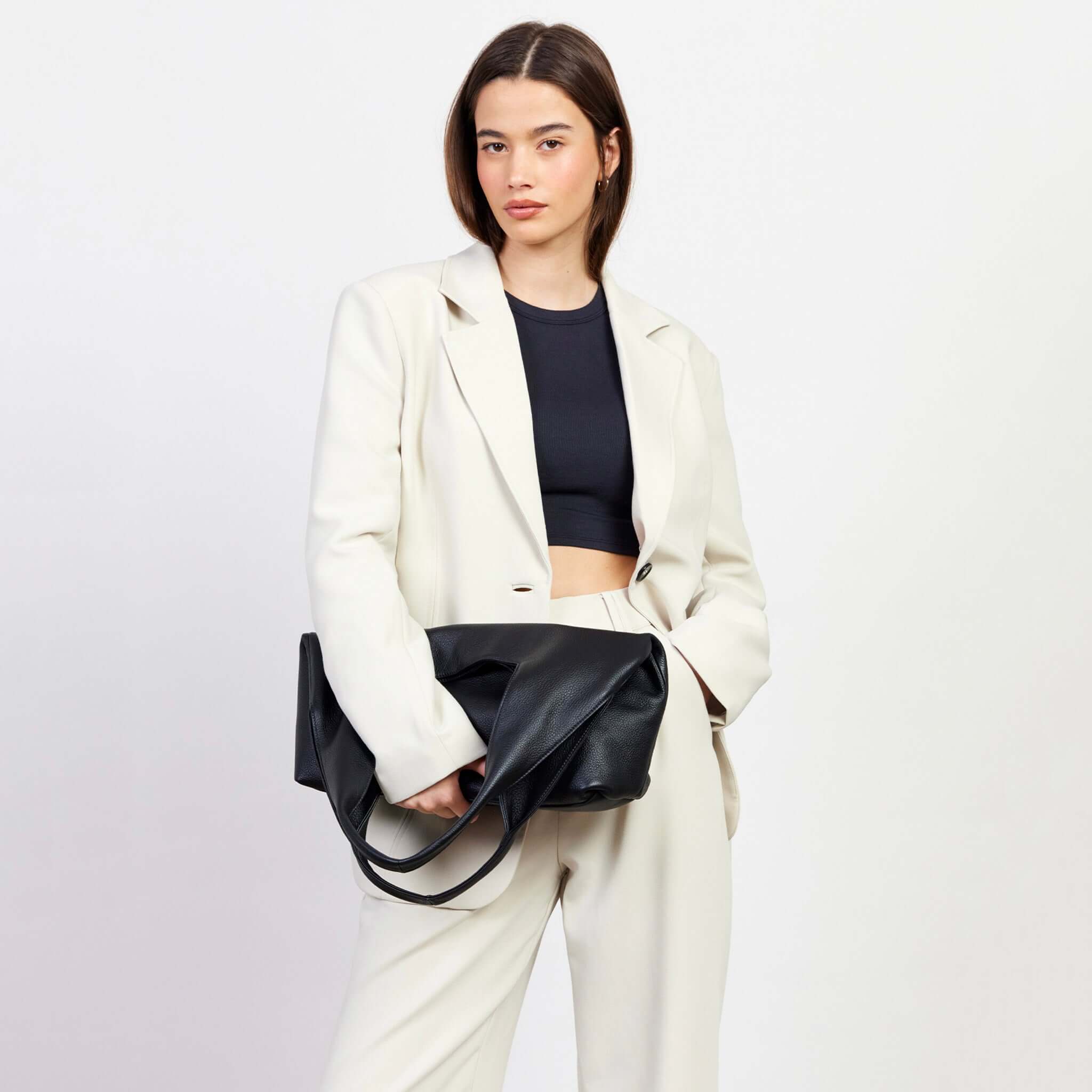 Saben Kip Shoulder Bag - Lightly Milled Black worn by model, slouchy black leather shoulder bag with relaxed drape and roomy everyday style