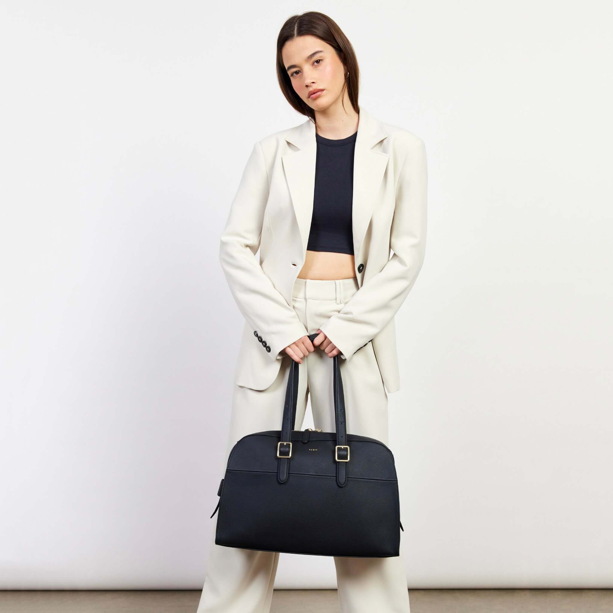 Alt Tag: Saben Marti Shoulder Bag - Black structured bowler bag with buckle shoulder straps and zip closure, worn by model