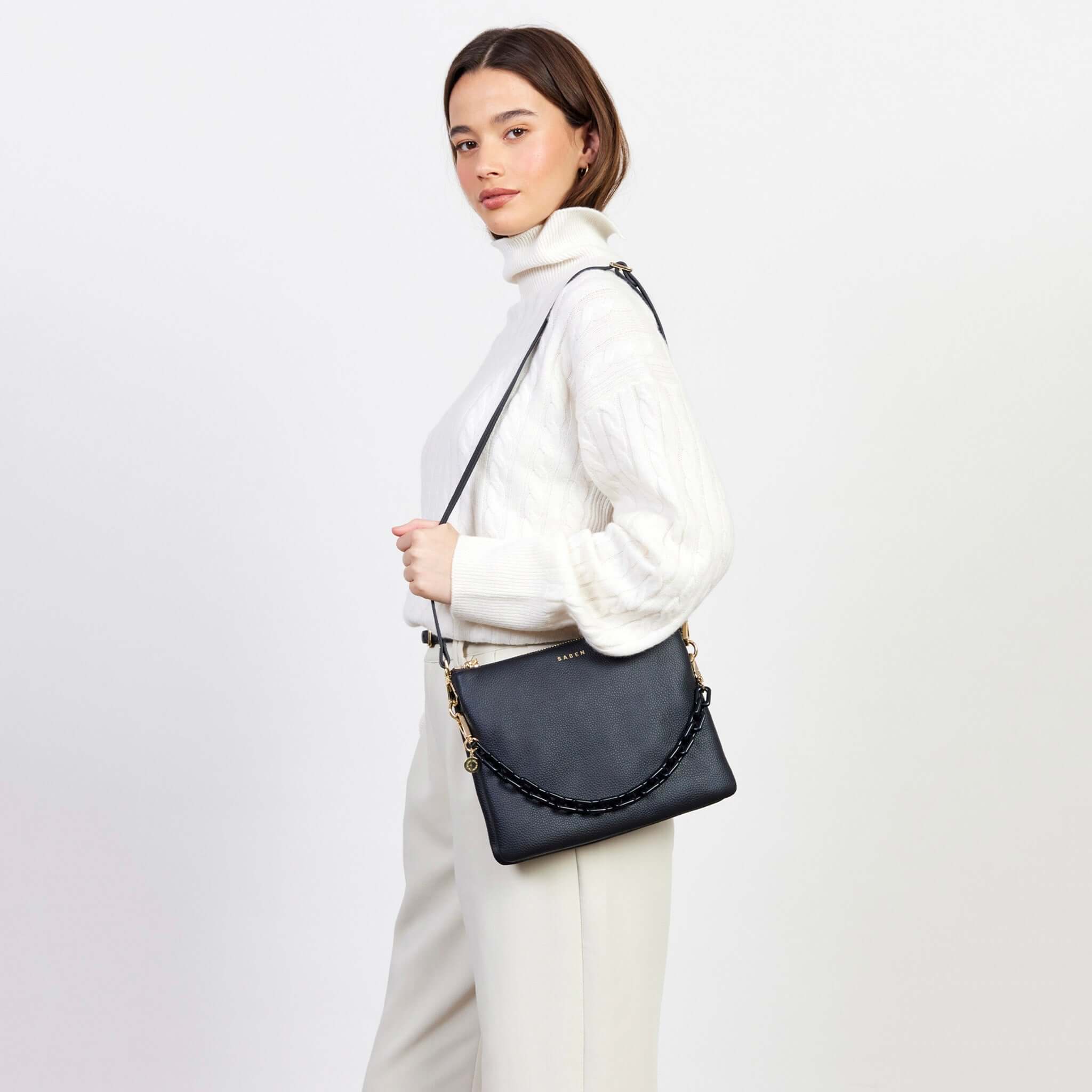Alt Tag: Saben Matilda Crossbody Bag - Black with Tonal Chain worn by model, luxe black leather crossbody with tonal chain strap