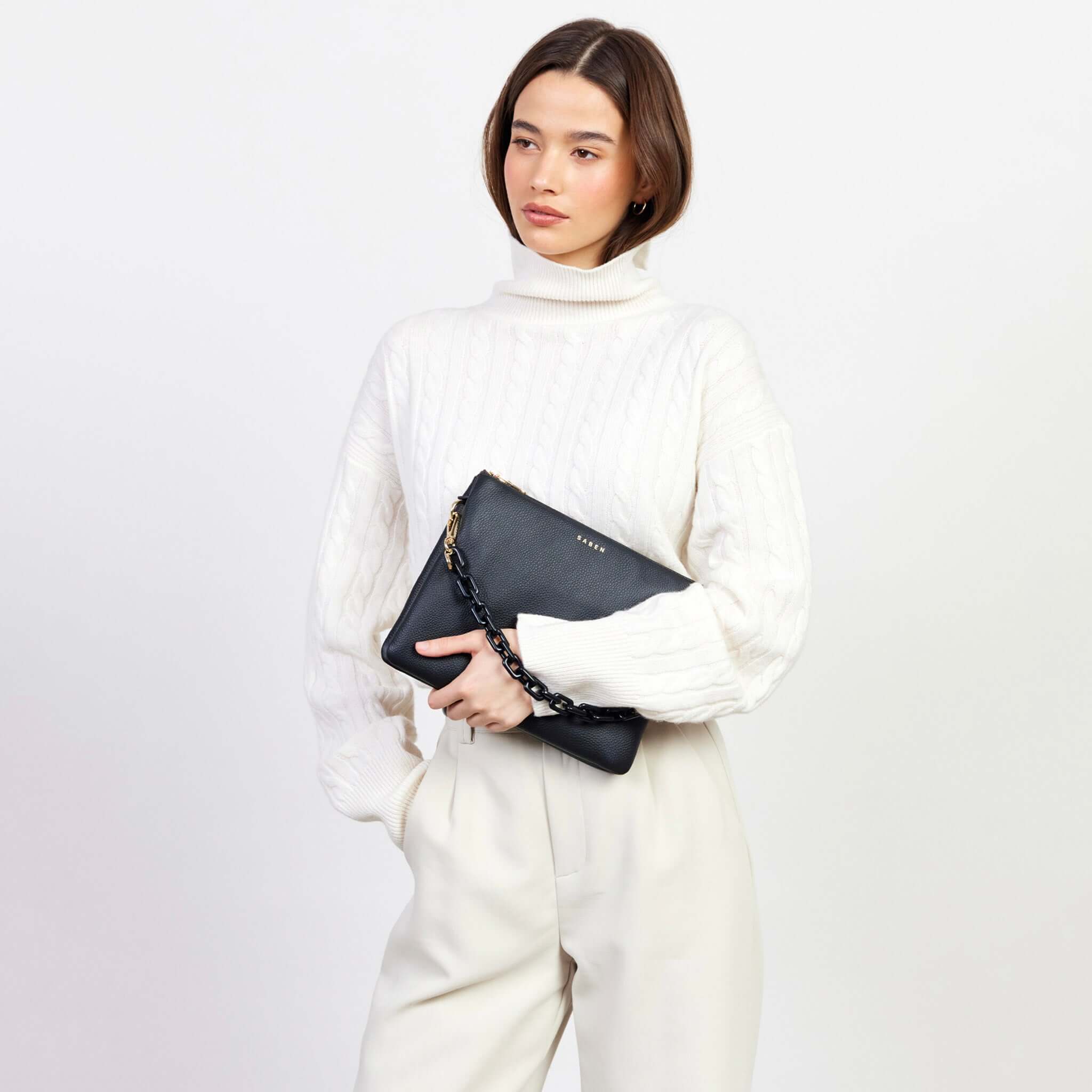 Alt Tag: Model holding Saben Matilda Crossbody Bag - Black with Tonal Chain, luxe black leather crossbody with tonal chain strap