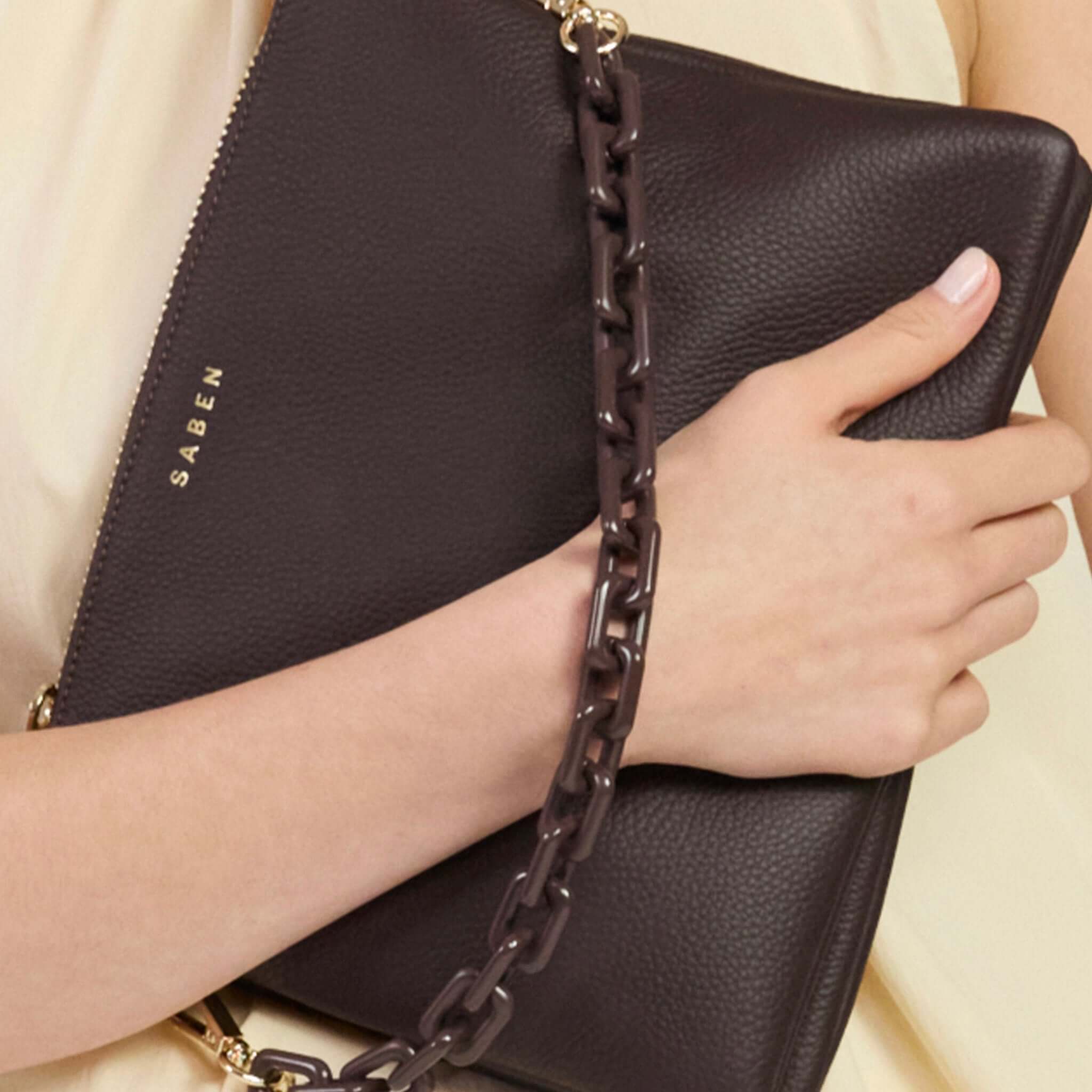 Saben Matilda Crossbody Bag - Cocao with Tonal Chain held elegantly by a model, showcasing its luxe design.