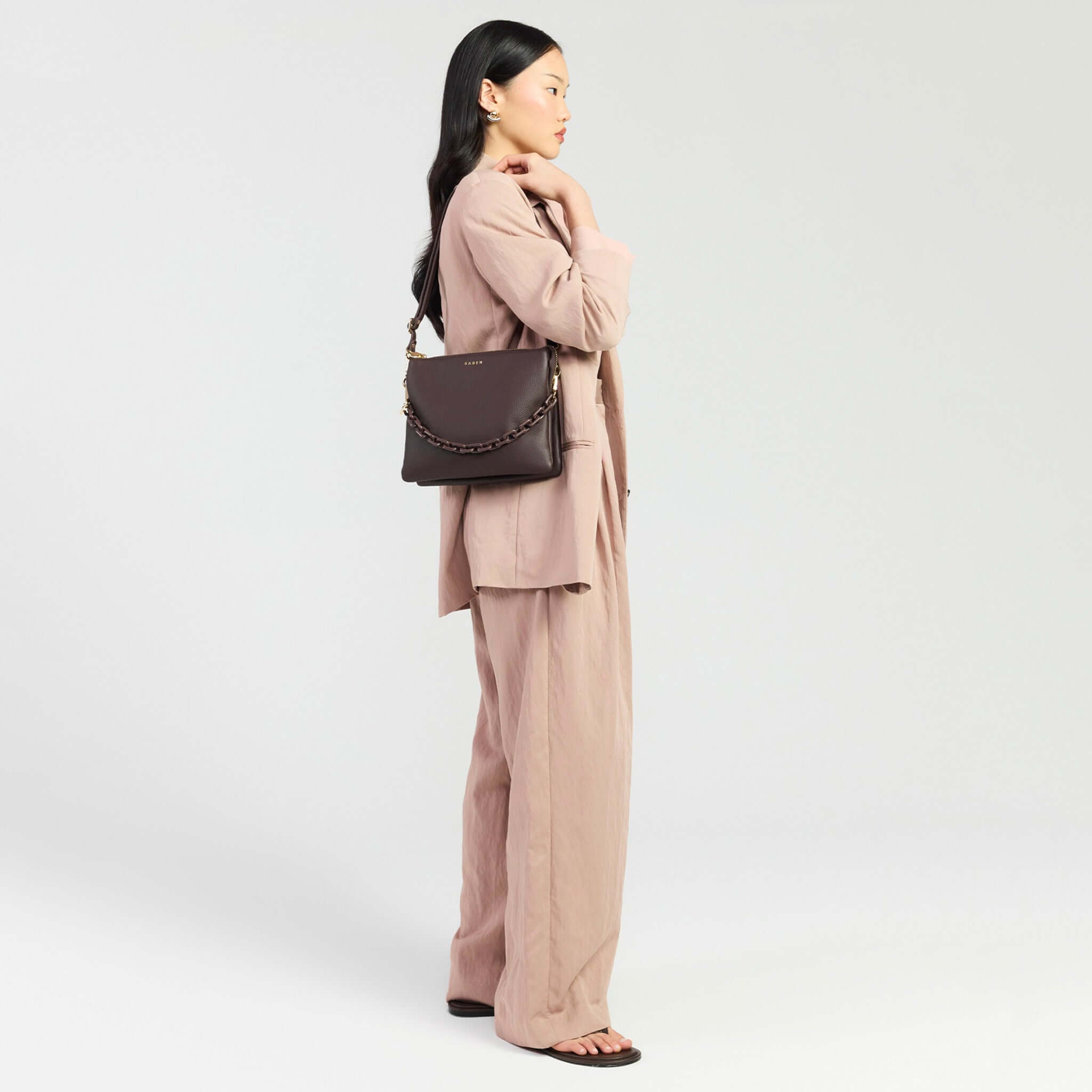 Saben Matilda Crossbody Bag - Cocao with Tonal Chain model wearing chic outfit, showcasing stylish bag on shoulder.