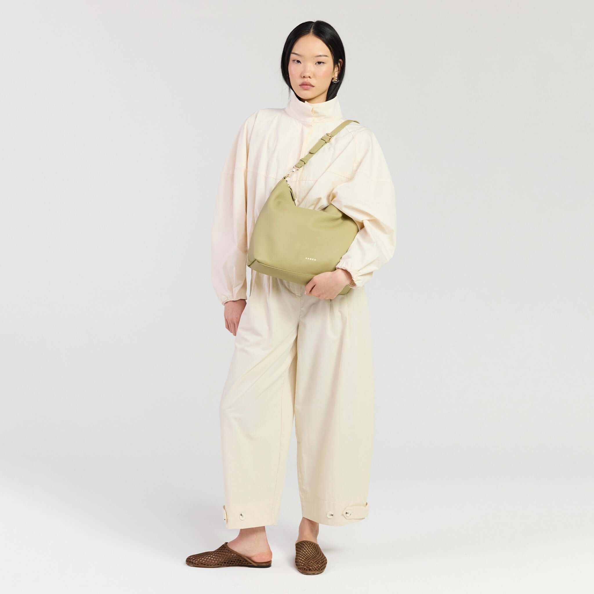 Model wearing Saben Miki Shoulder Bag - Willow Luxe, styled with oversized cream outfit and casual slides.