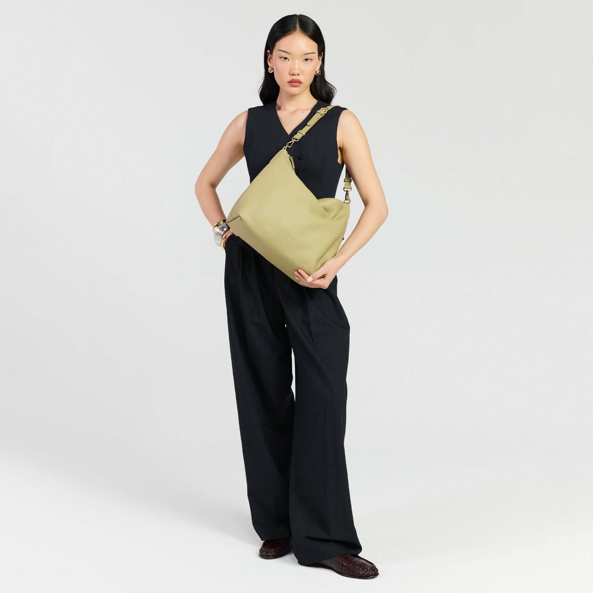 Model holding Saben Miki Shoulder Bag - Willow Luxe, showcasing its stylish and practical design in Willow color.