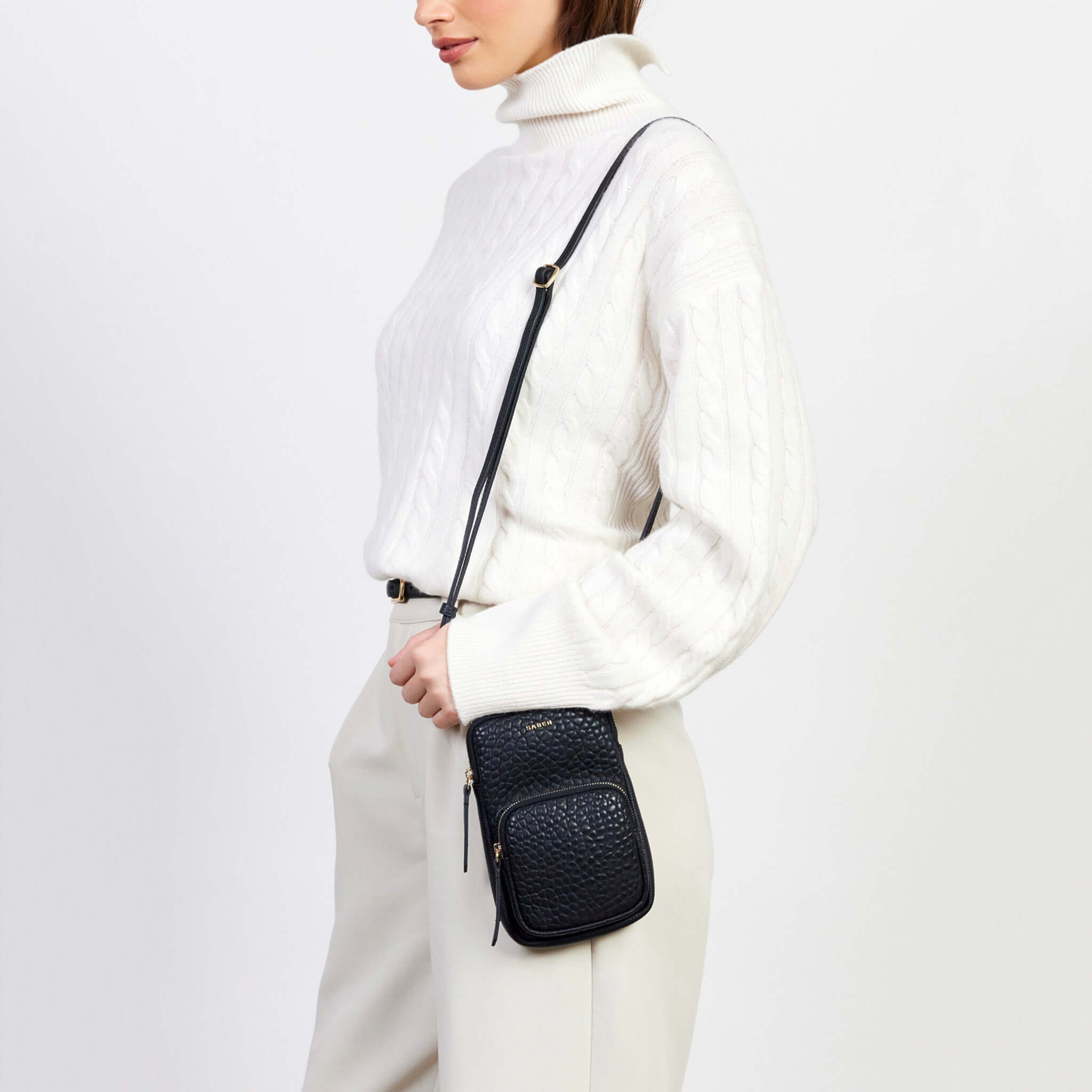 Alt Tag: Saben Nikko Phone Sling - Black Bubble crossbody phone sling with adjustable strap and textured finish, worn hands-free