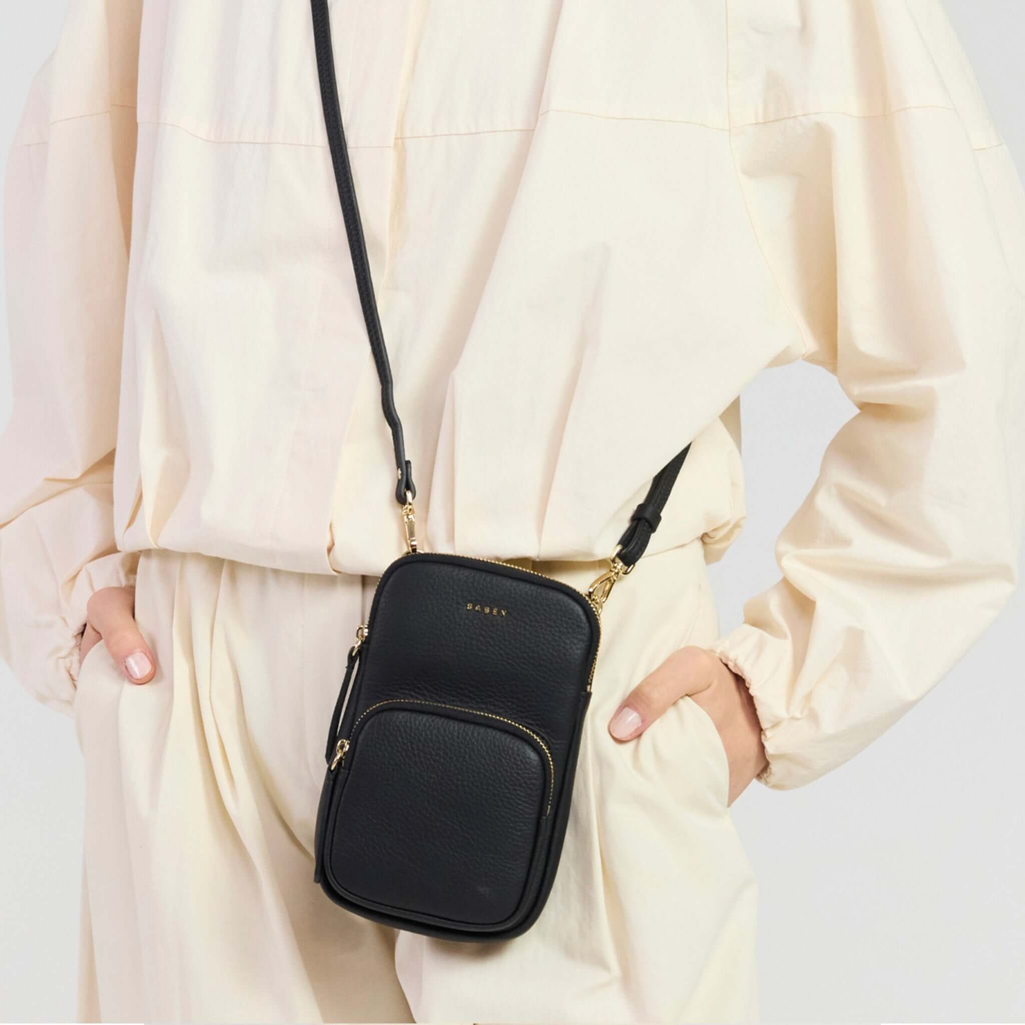 Saben Nikko Pocket Phone Sling - Black Luxe worn by model with a minimalist outfit.