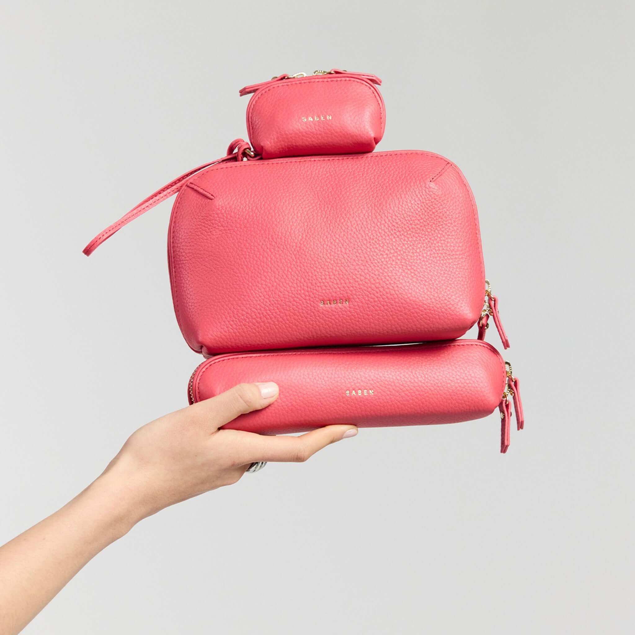 Saben Tarin Small Wristlet Pouch - Azalea stacked with other pink bags showcasing stylish versatility.