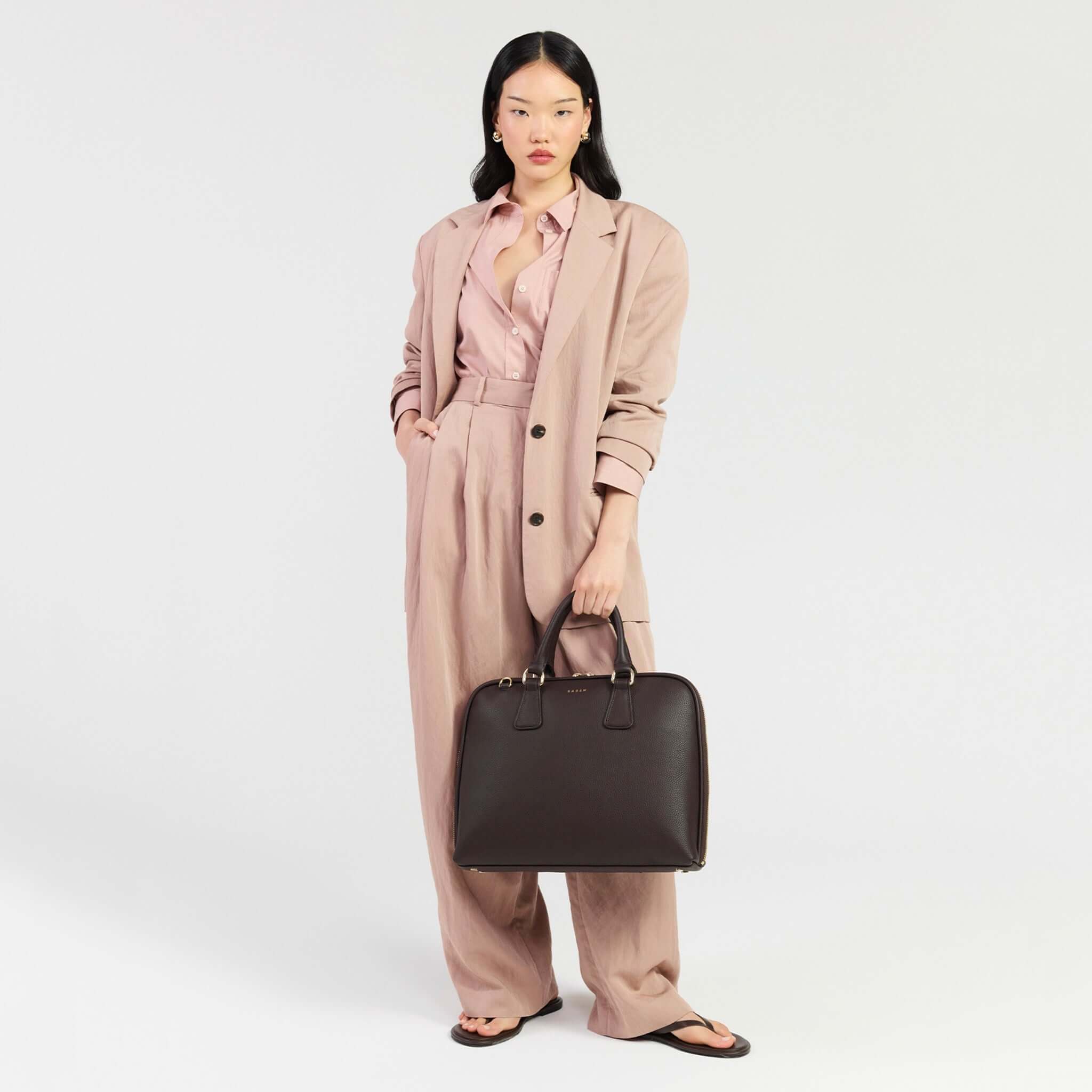 Model showcasing Saben Parker Briefcase - Cacao with a stylish outfit in a modern setting.