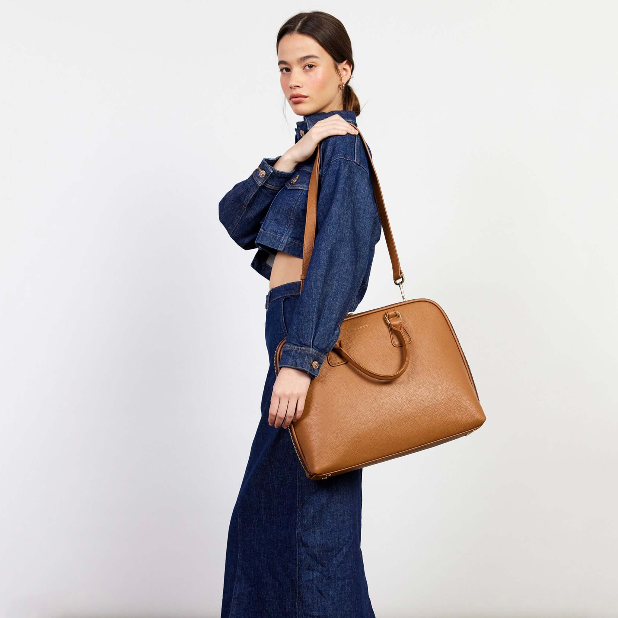 Alt Tag: Saben Parker Briefcase - Toffee toffee leather laptop briefcase with shoulder strap, carried by model for work, commuting and travel