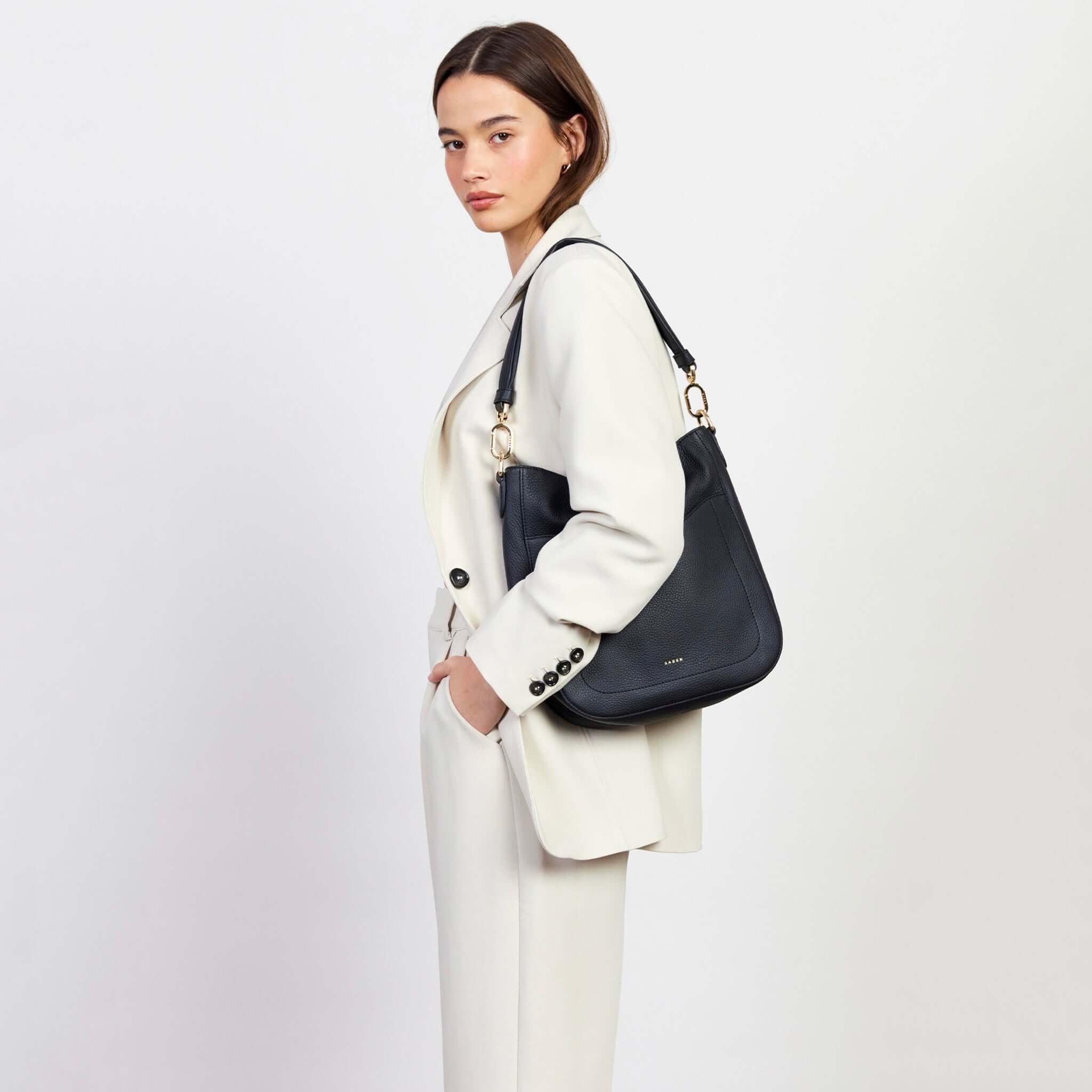 Alt Tag: Saben Rebe Shoulder Bag - Black in black pebbled leather hobo style, worn over shoulder with detachable strap