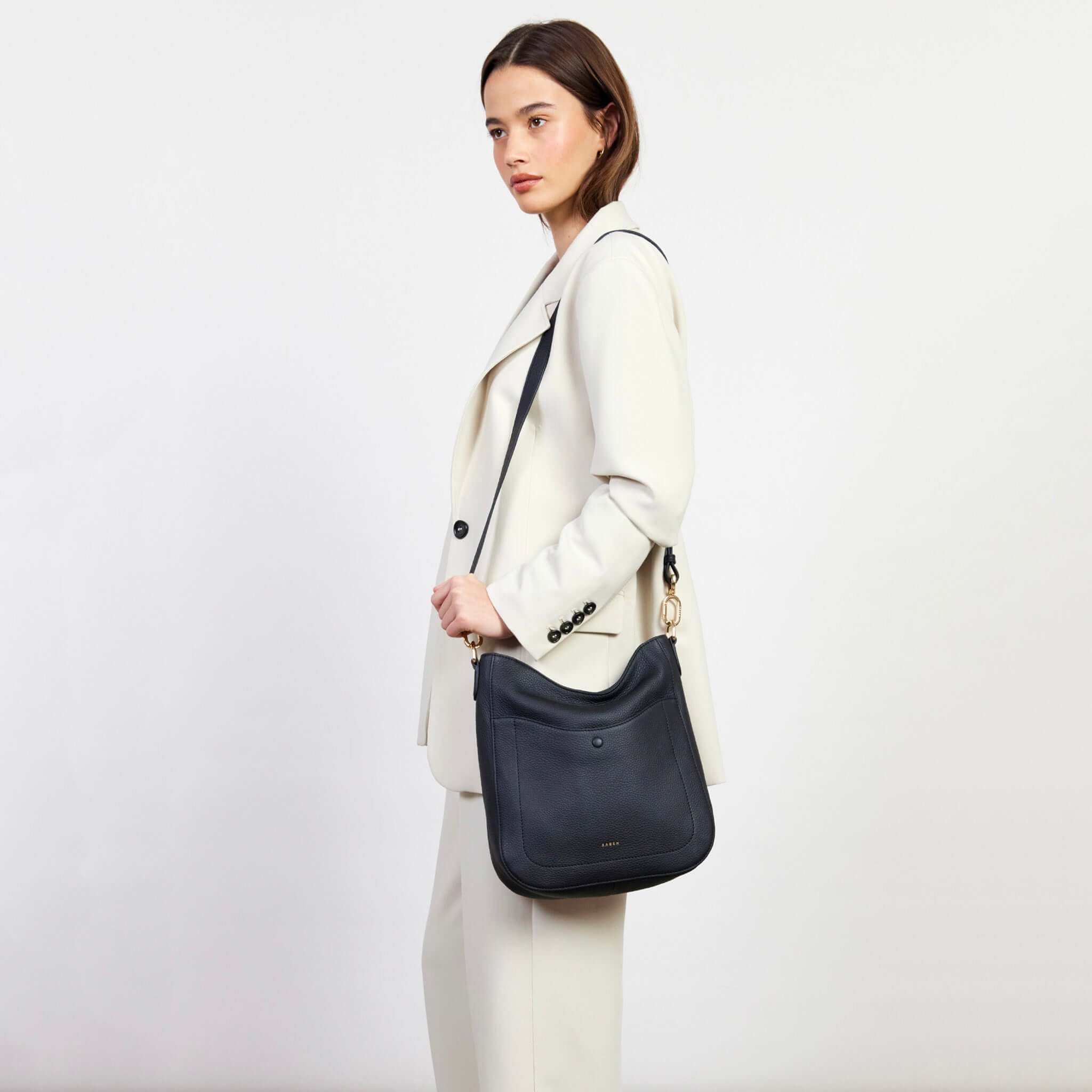 Alt Tag: Saben Rebe Shoulder Bag - Black pebbled leather hobo bag worn crossbody with detachable strap and front magnet drop pocket